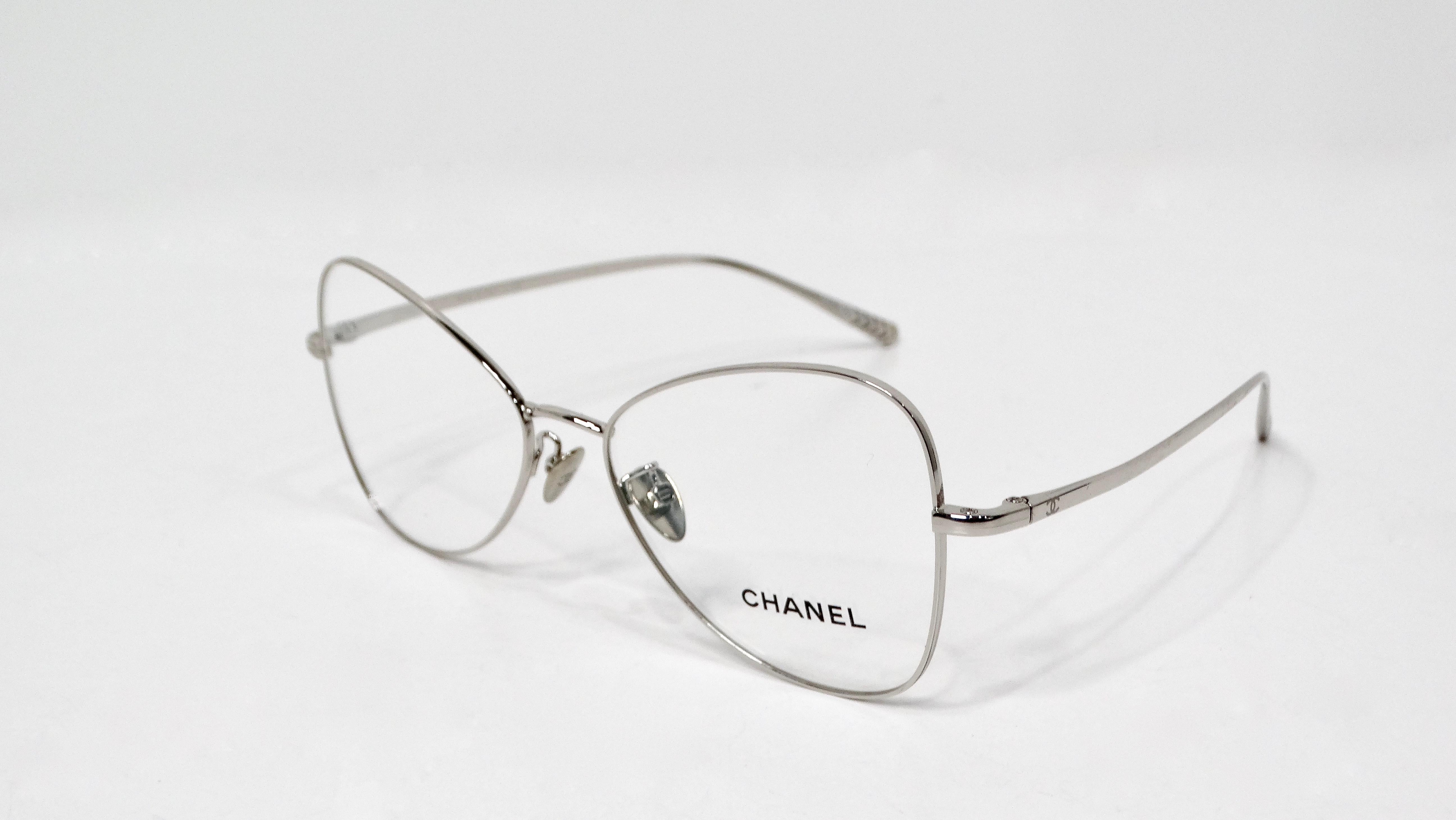 The Chanel 2019 Silver-Tone Metal Frame Butterfly Style Eyeglasses epitomize elegance and sophistication, showcasing a distinctive design that effortlessly complements any fashion enthusiast’s collection. Crafted from sleek silver-tone metal, the