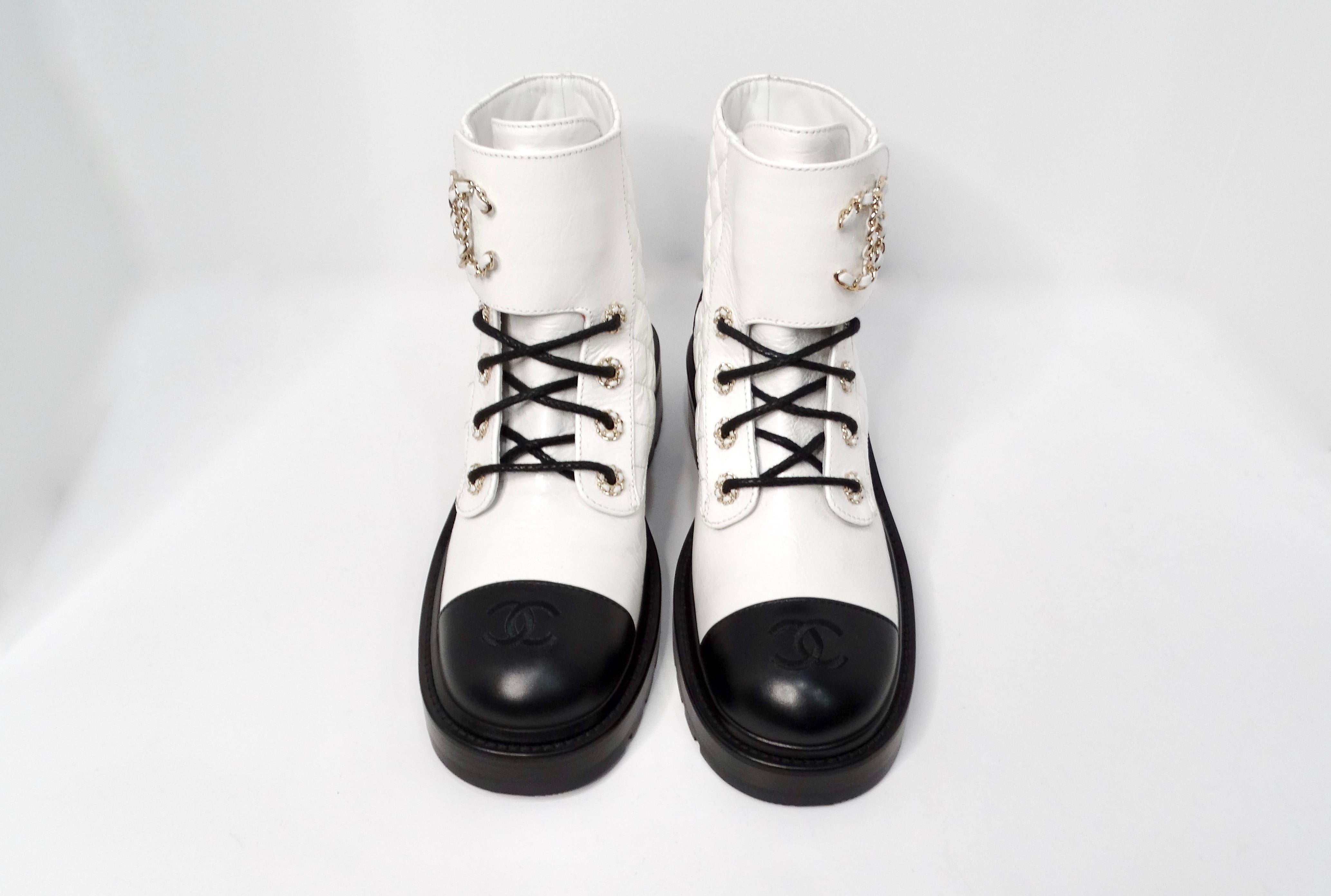 Las botas de combate Chanel 2020 de piel de cabra blanca brillante con logotipo CC entrelazado son una declaración de calzado lujosa y moderna. Confeccionadas en exquisita piel de cabra blanca brillante, estas botas presentan meticulosos detalles