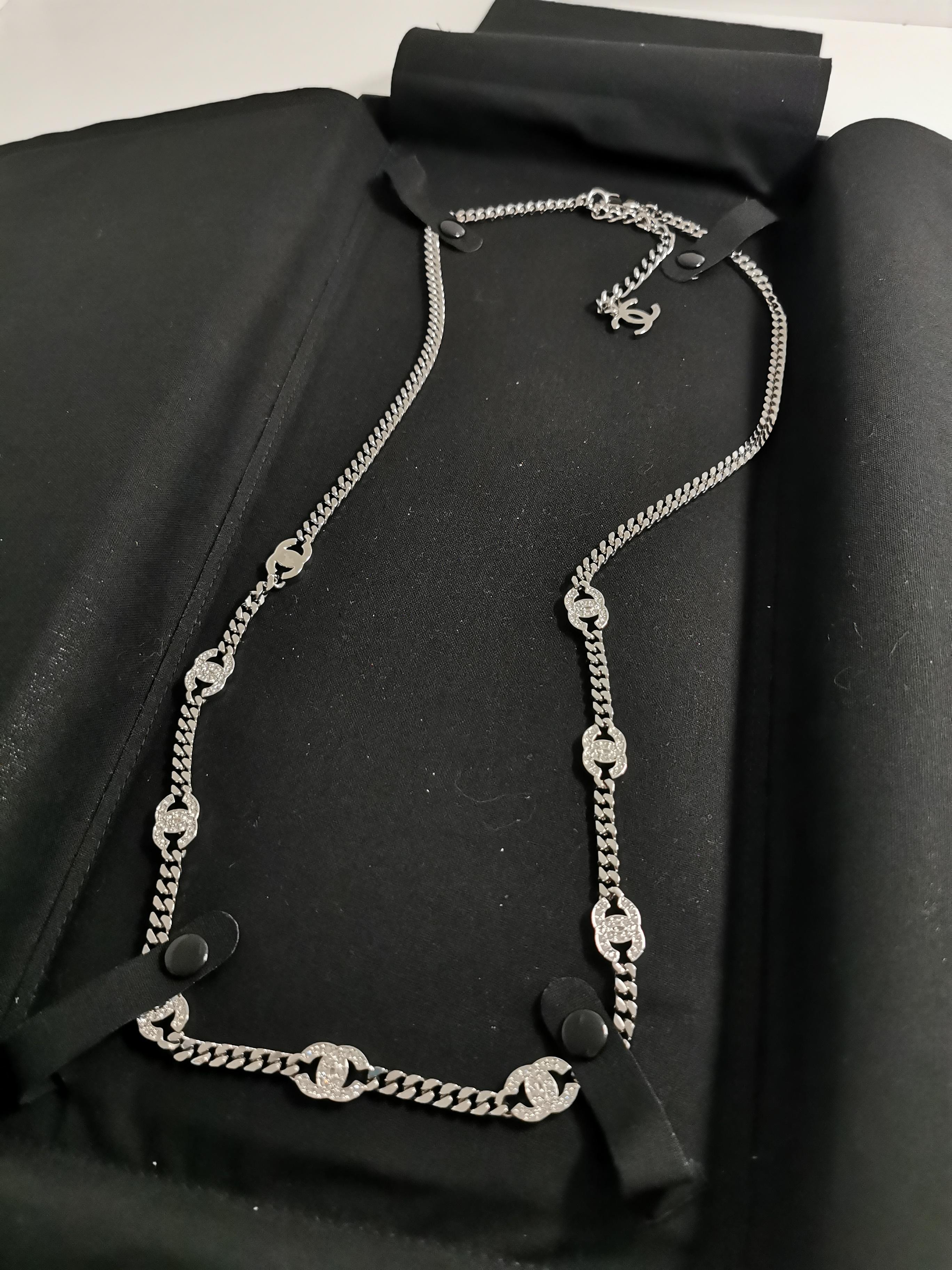 Mit der Chanel 2021 CC Rhinestones Chain in Gunmetal Silver, einem vielseitigen Schmuckstück, das sich mühelos in eine atemberaubende Taillenkette oder eine exquisite Halskette verwandeln lässt, erheben Sie Ihren Stil zum Gipfel des Luxus. Diese