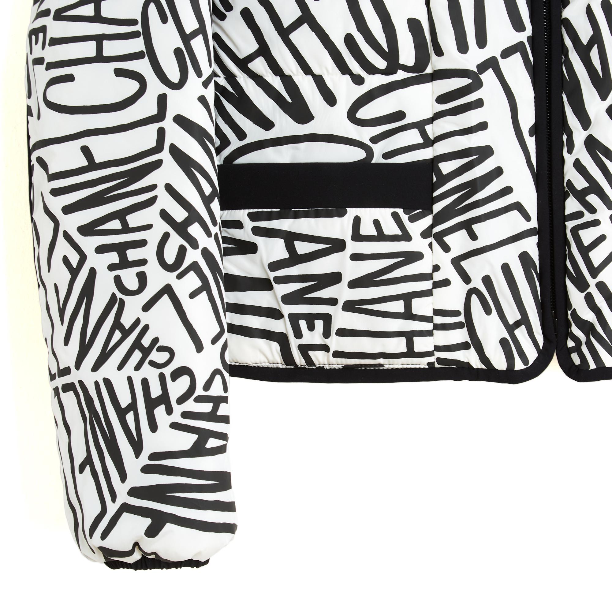 Chanel Coco Neige collection 2021 doudoune réversible à capuche en polyamide et polyester noir. L'un des côtés est noir et comporte quatre poches à boutons-pression et deux poches latérales zippées dissimulées. L'autre face présente un imprimé