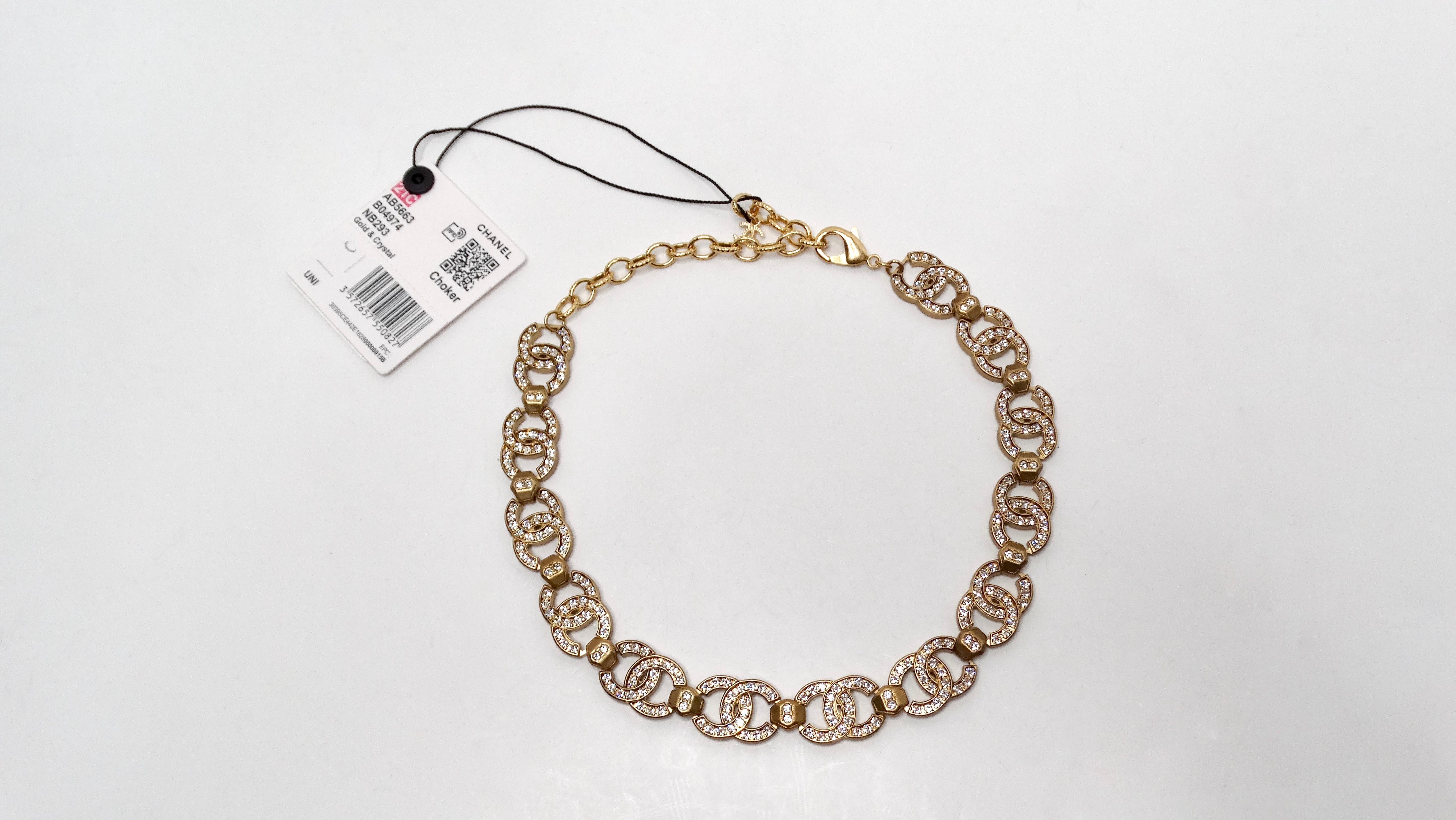 El collar gargantilla con el logotipo CC entrelazado de Chanel 2021 en tono dorado encarna el lujo y la elegancia, convirtiéndolo en un accesorio imprescindible para cualquier aficionado a la moda. Fabricada en exquisito metal dorado, esta llamativa