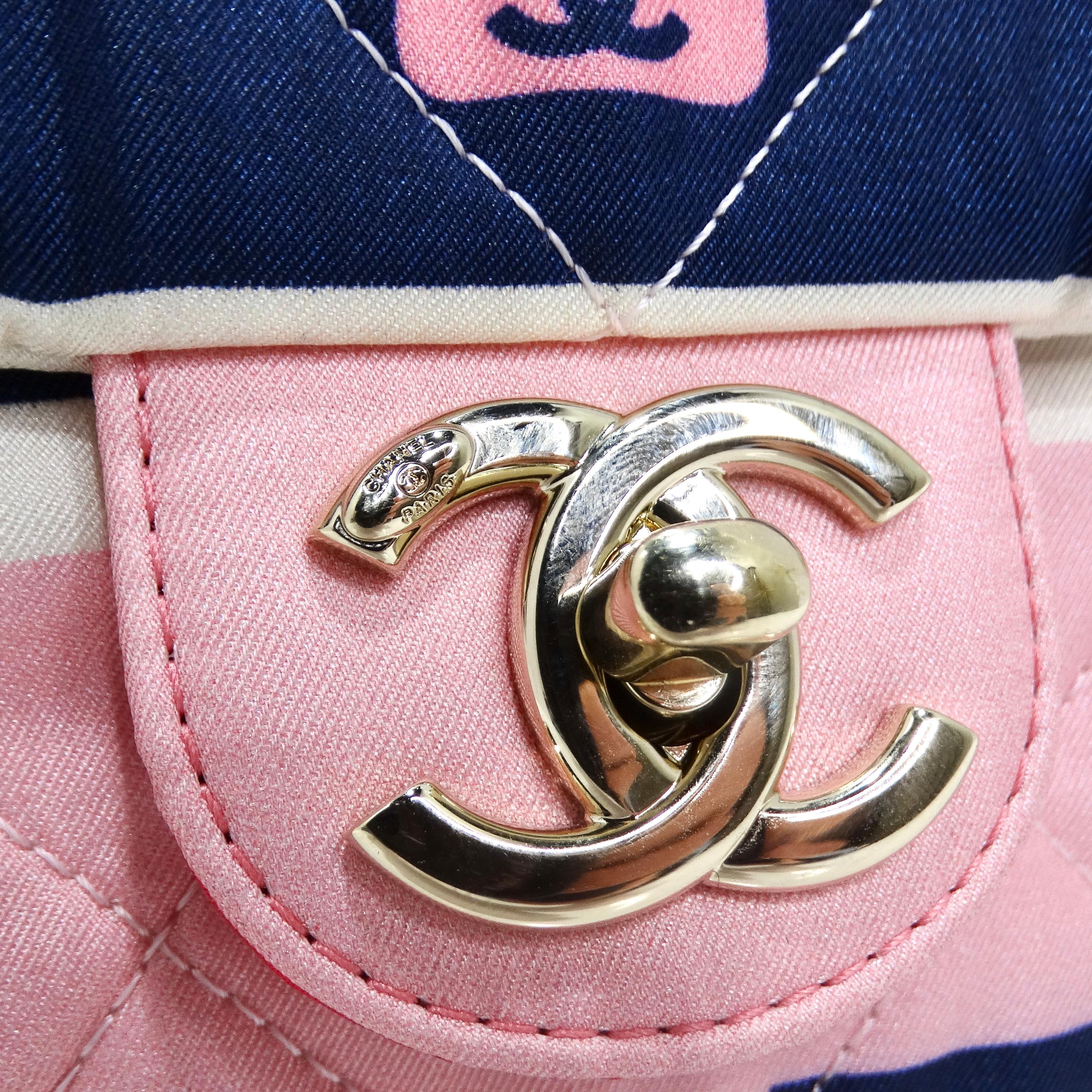 Introducing the Chanel 2021 Jumbo Print Graphic Pink Black Quilted Flap Shoulder Bag – a whimsical and vibrant addition to your collection. This classic Chanel Flap bag features a playful gradient pink and navy print adorned with images of Chanel