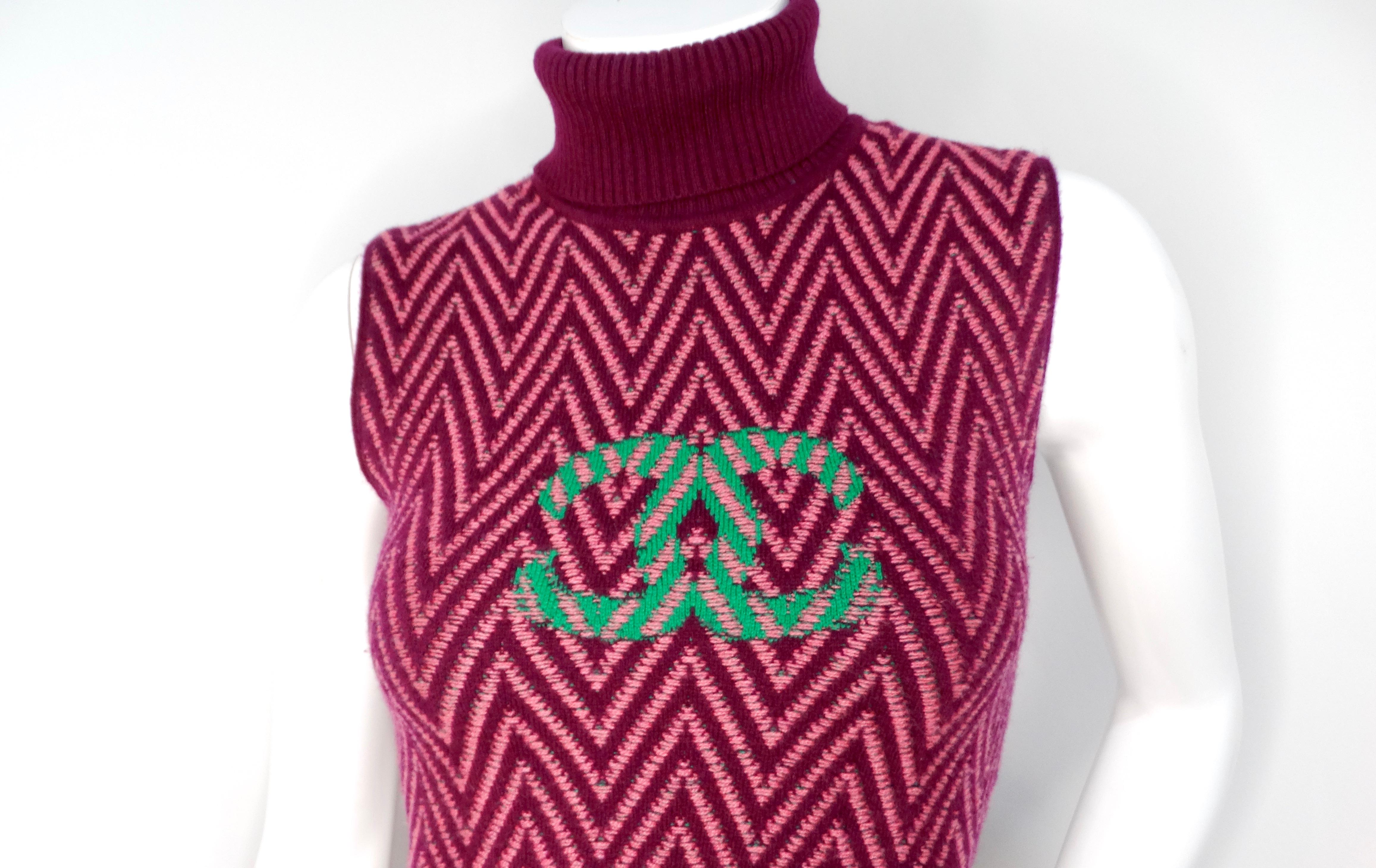 Eleva il tuo guardaroba con lo splendido Chanel 2021 Mini Purple Cashmere Turtleneck Dress, una vera e propria testimonianza di lusso giocoso e stile contemporaneo. Questo vestito accattivante presenta un vivace motivo a zig-zag nei toni del viola e