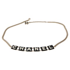 Chanel 2022 Cinturón con logotipo chapado en oro y esmaltado en blanco y negro