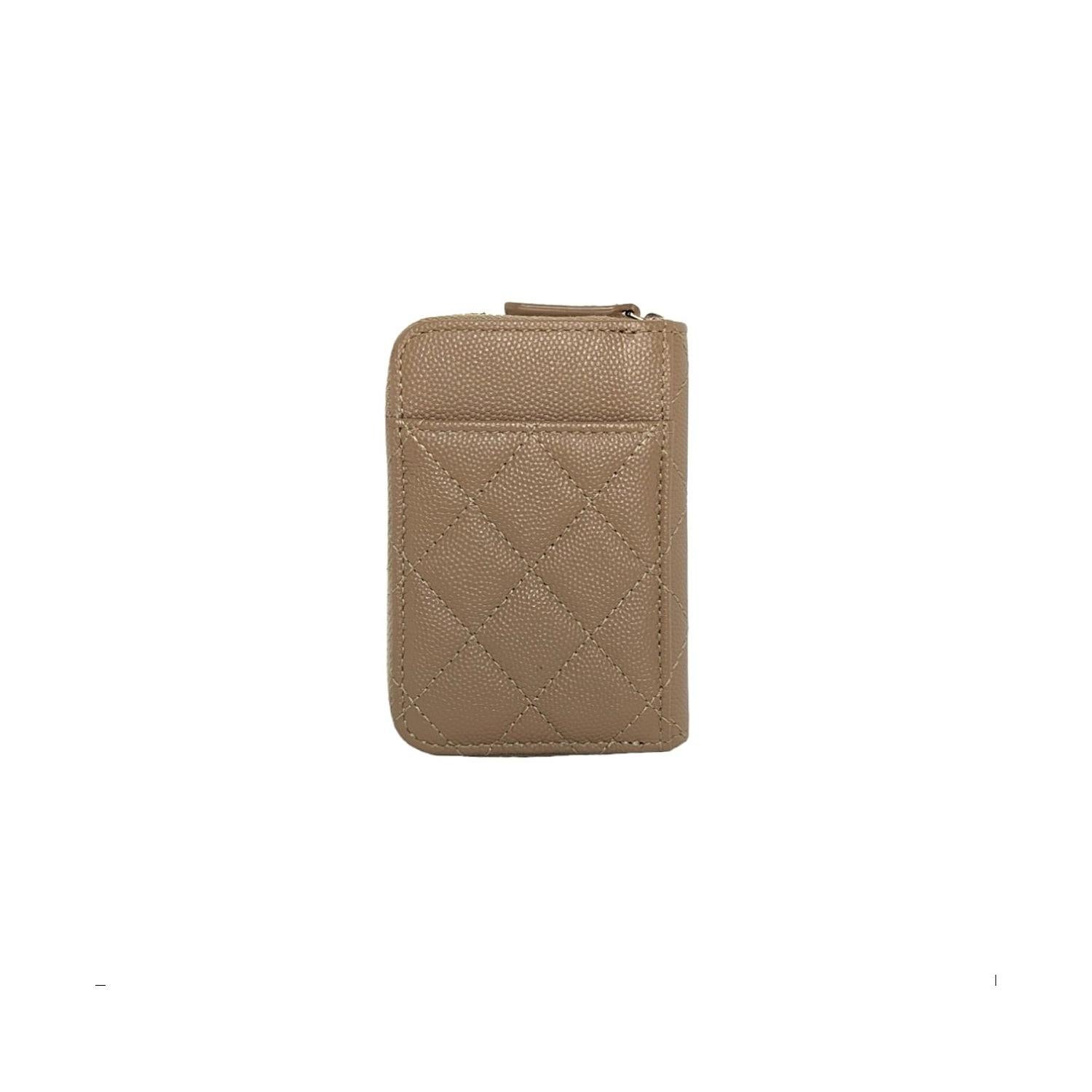 This petite wallet is crafted of dark beige caviar leather and features card slots on back and front, and a 3/4 wrap-around light gold zipper and a small polished light gold CC logo on the front. The zipper opens to a partitioned matching fabric