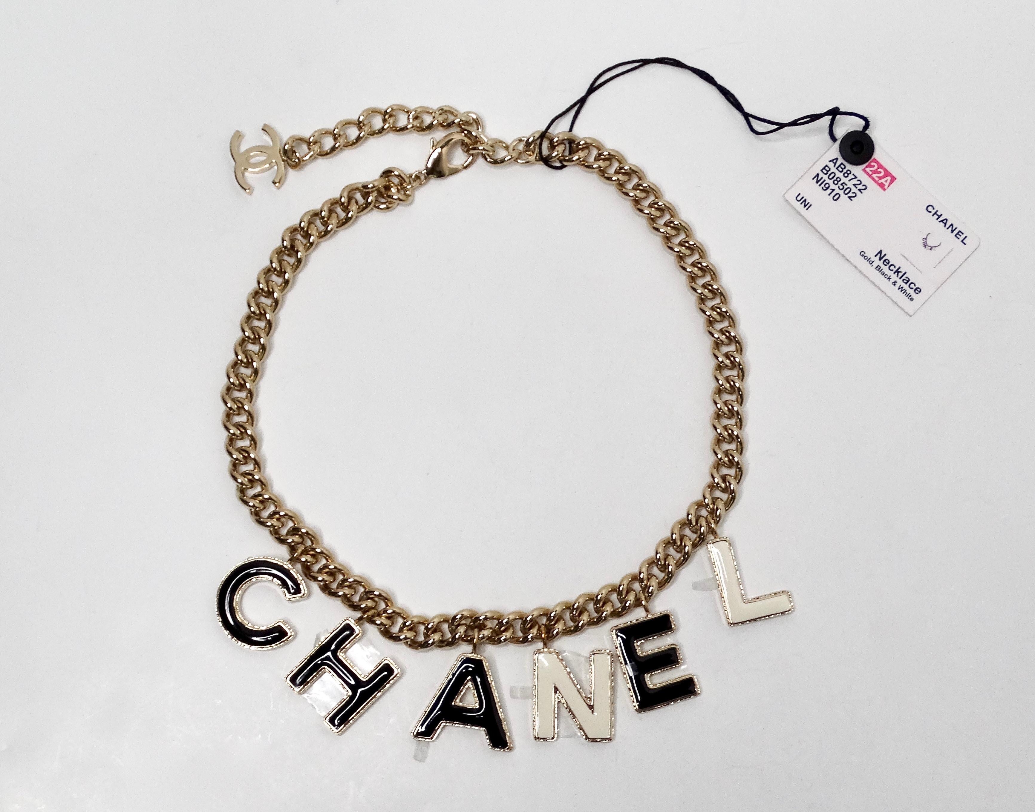 La collana Chanel 2022 Gold-Tone Black & White Logo Charm A Link è un pezzo sorprendente che cattura senza sforzo l'essenza del lusso e della raffinatezza. Caratterizzata da un'elegante catena dorata, questa collana mostra una serie di affascinanti
