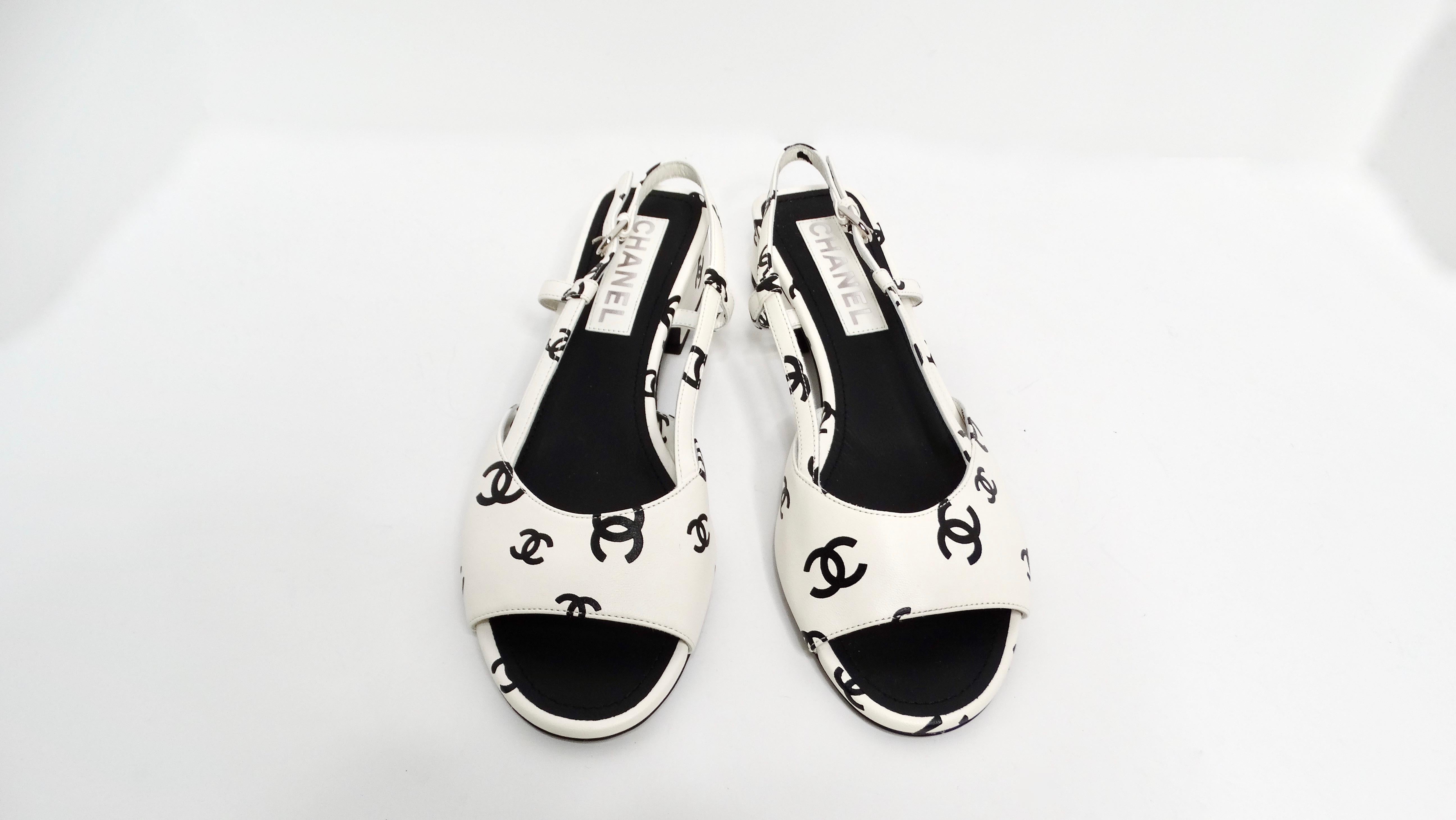 The Chanel 2022 Lambskin White & Black Interlocking CC Print Slingback Sandals are a luxurious addition to any fashionista's wardrobe. Crafted from lambskin, these sandals feature an elegant white open toe design that refreshes classic styling while