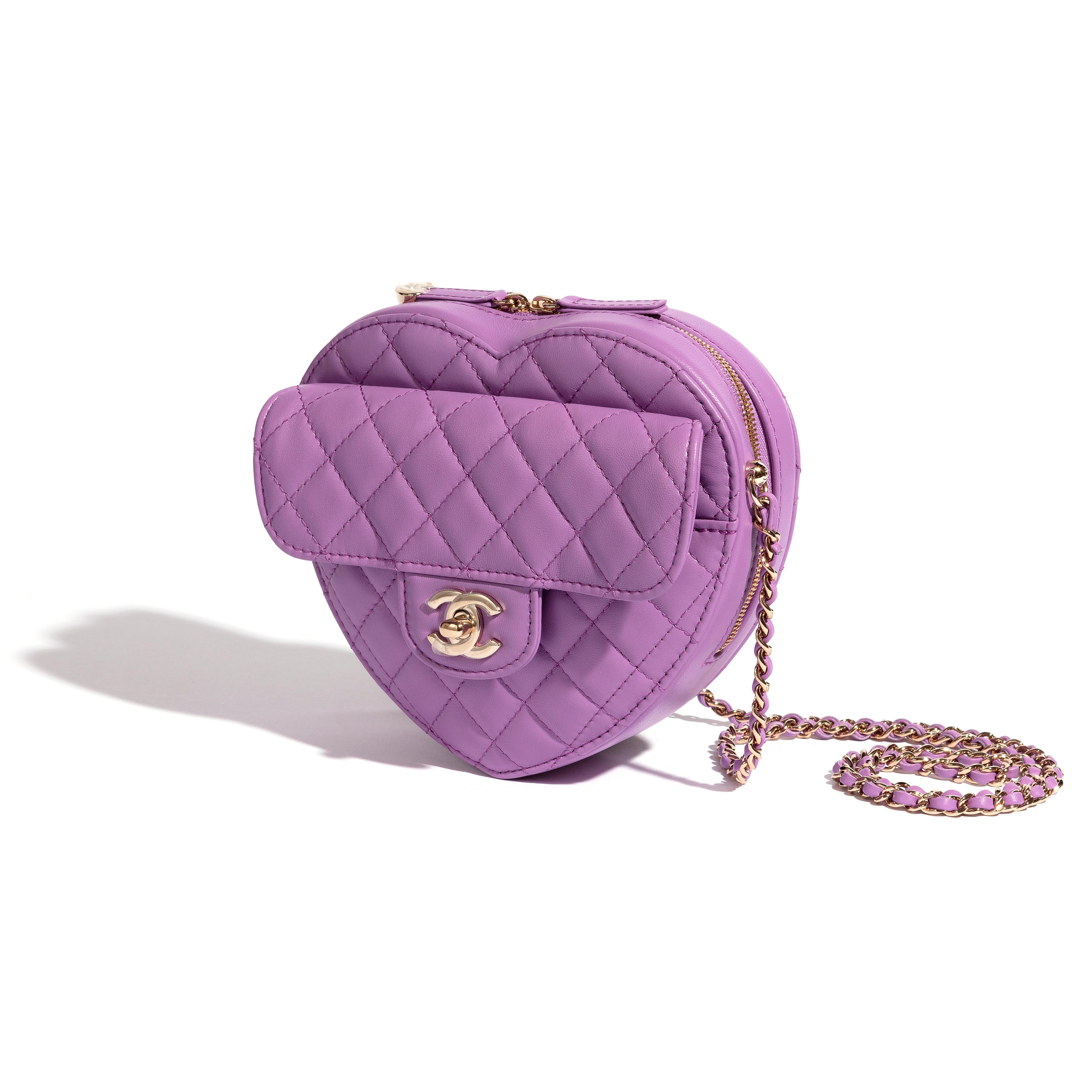 A coveted lilac Chanel Heart Bag. The exterior of this Heart Bag is crafted with lilac lambskin leather in the signature diamond style stitching with silver-tone hardware and has a signature logo zipper pull. It features a front flap with signature
