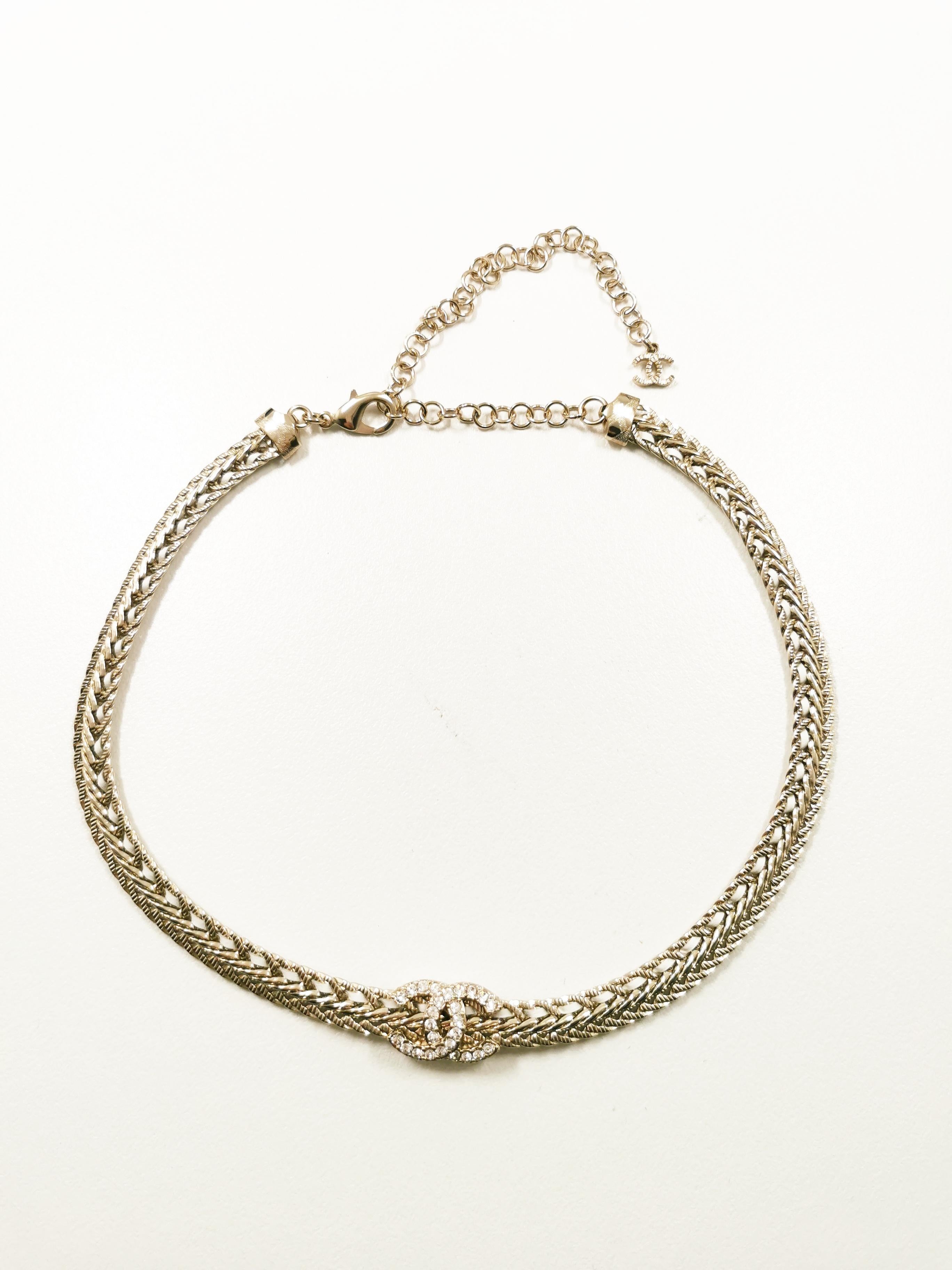 Introducing the exquisite Chanel 22S Gold White Chain Crystal CC Logo Short Choker, a stunning piece of jewelry that epitomizes luxury and elegance. This opulent choker captures the essence of Chanel's timeless design, showcasing a harmonious blend