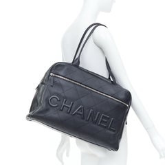 CHANEL 2023 black quilted calfskin stitched maxi spellout logo bowling bag