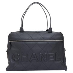 CHANEL 2023 black quilted calfskin stitched maxi spellout logo bowling bag