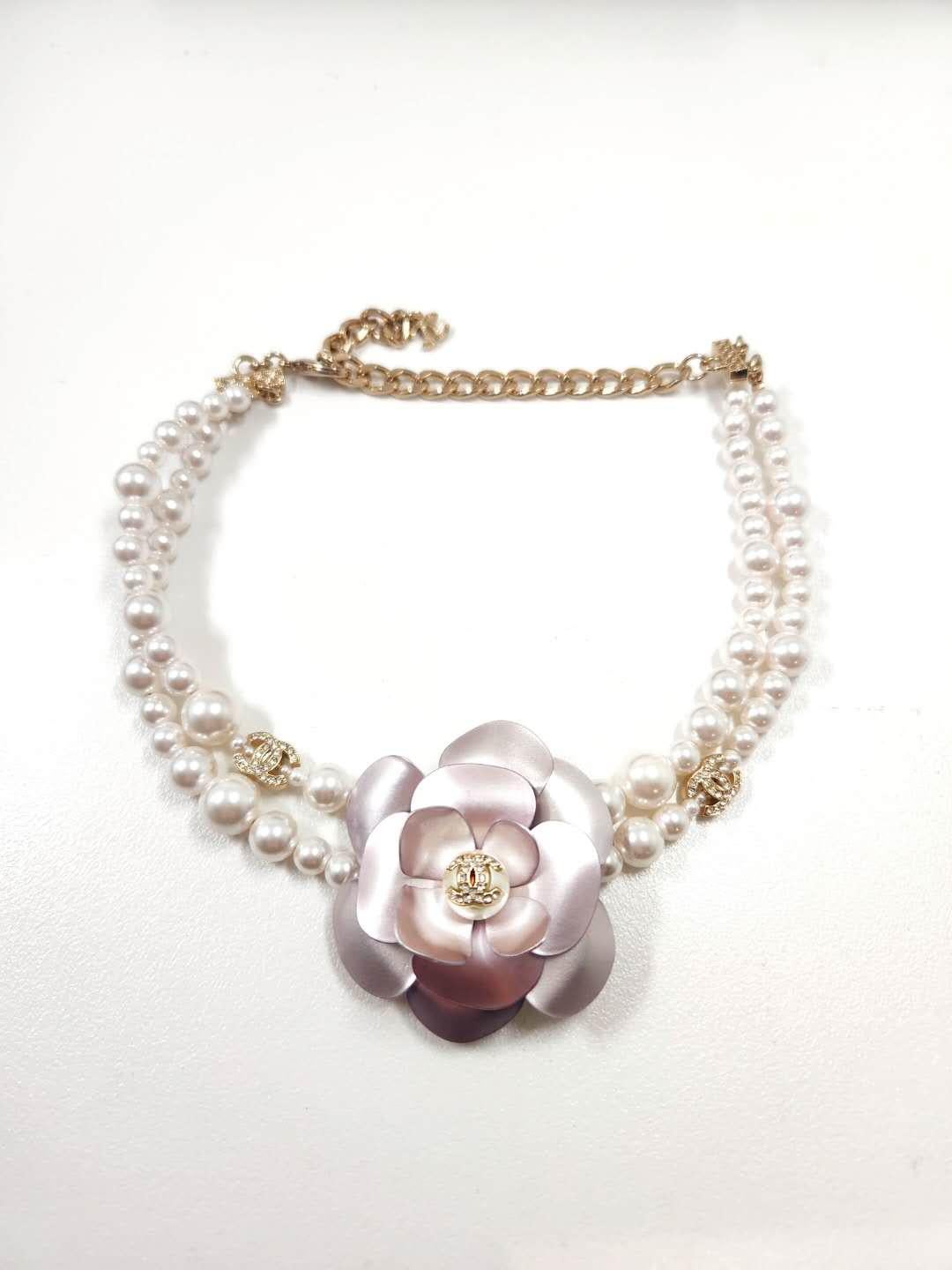 Introducing the breathtaking CHANEL 2023 Camellia Double Layer Pearl Choker Necklace with Rhinestone CC center, a masterpiece that encapsulates the essence of Chanel's timeless elegance and iconic design. This exquisite necklace effortlessly