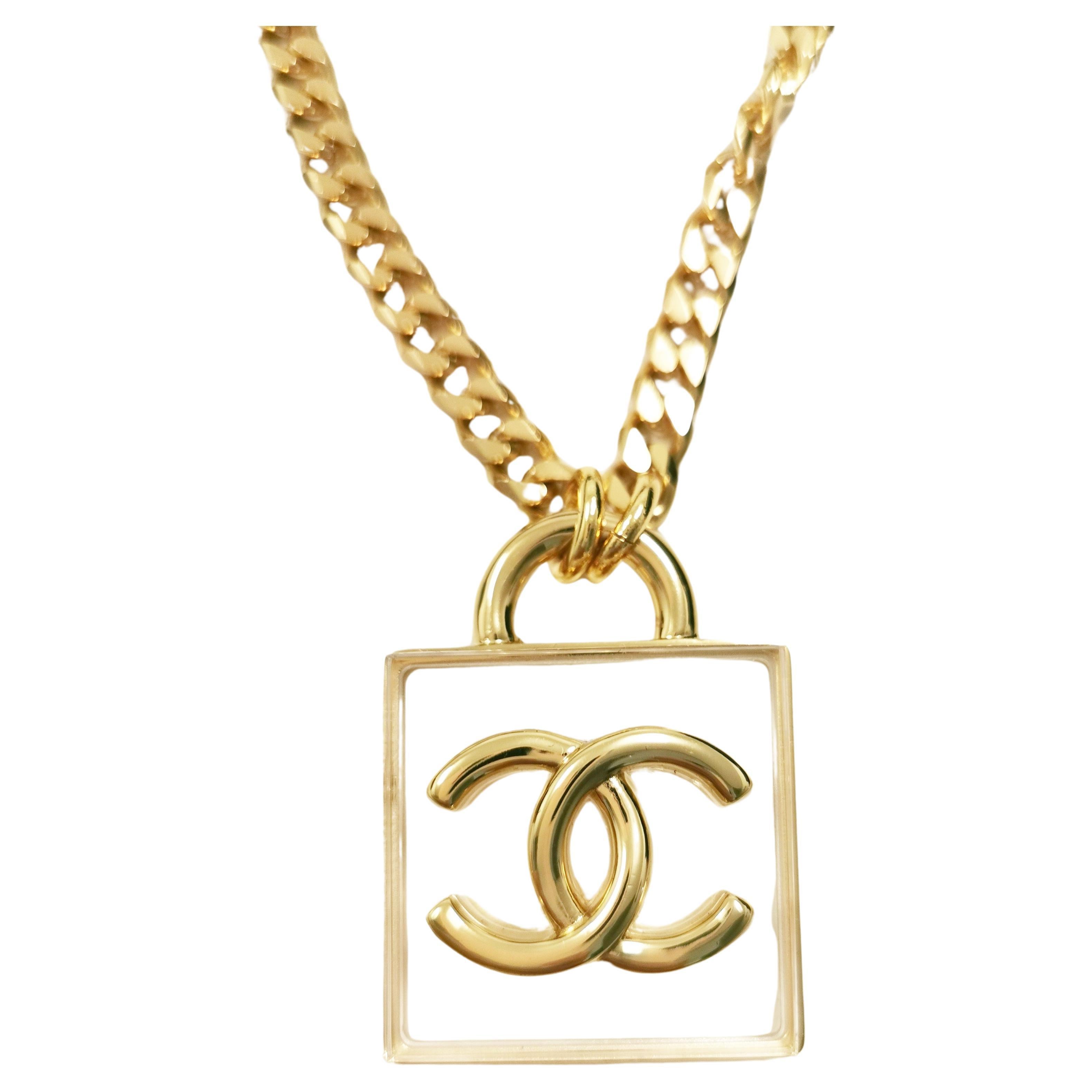 Introducing the CHANEL 2023 Spring/Summer Collection's CC Square Resin Gold Long Chain Necklace - a true embodiment of timeless elegance and sophistication. This exquisite piece of jewelry seamlessly blends classic CHANEL design elements with a
