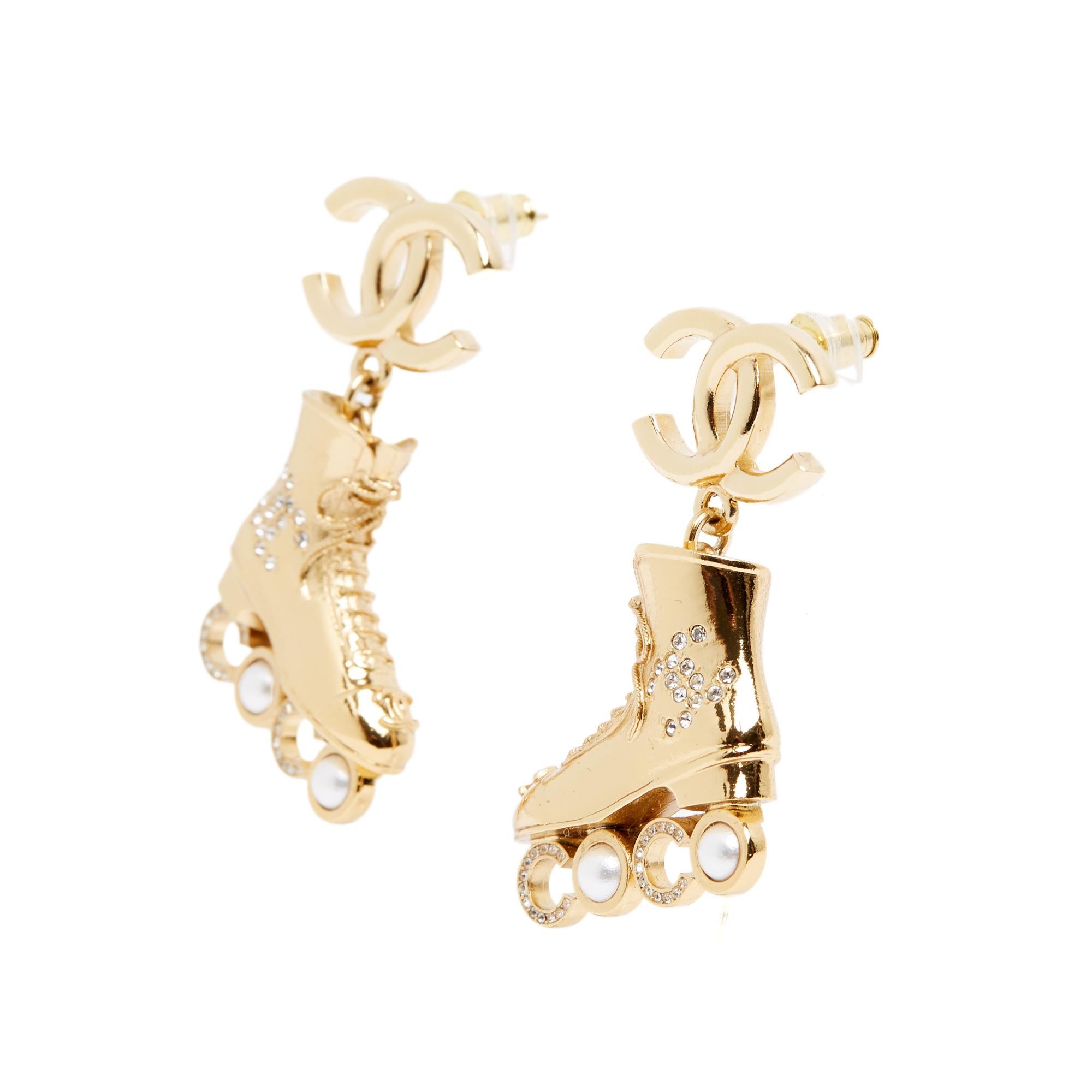 Chanel stud earrings from the Cruise, Resort collection 2024, Coco model with a large CC logo motif and a roller-shaped pendant decorated with a CC motif encrusted with rhinestones with Coco logo wheels encrusted with small fancy pearls and micro