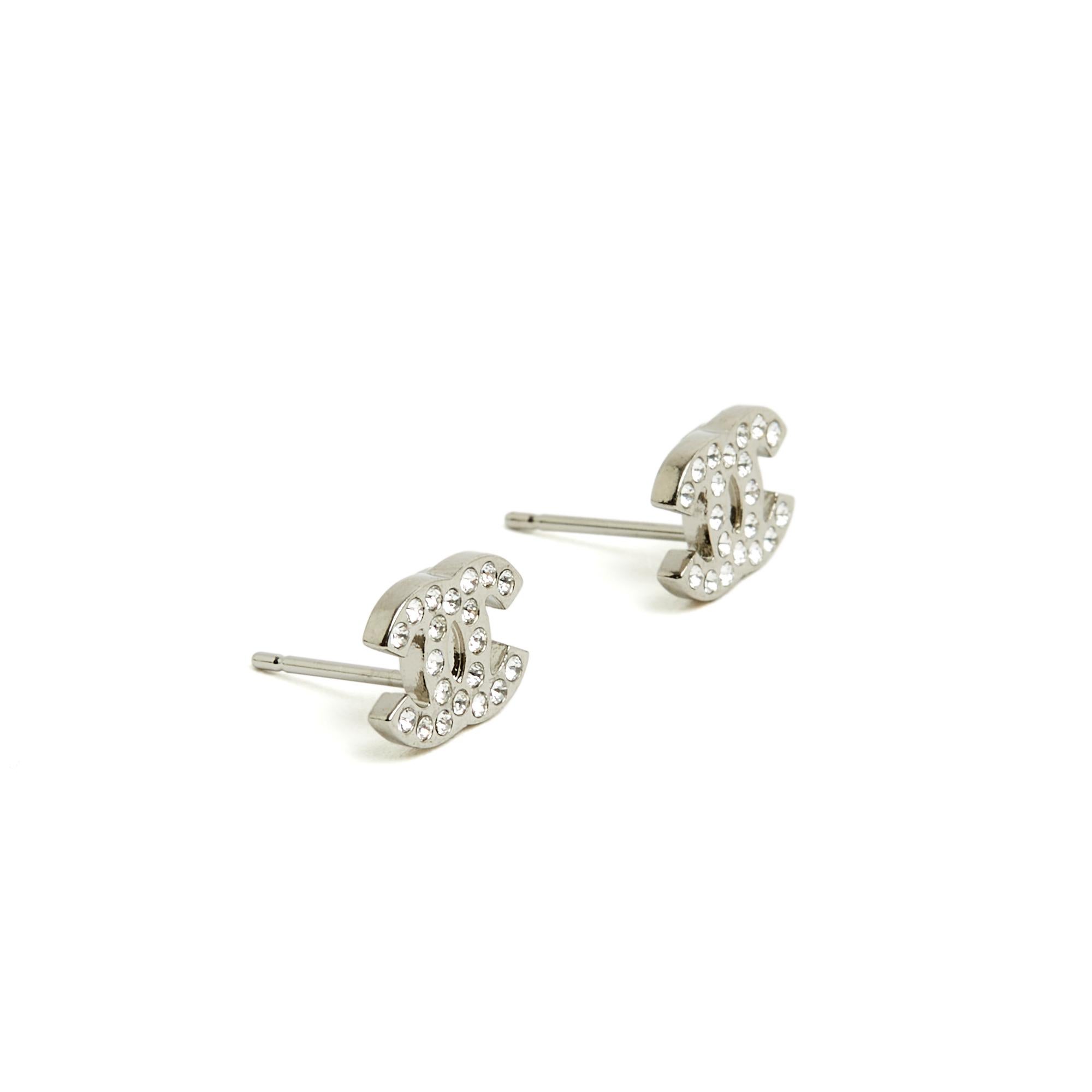Chanel mini stud earrings in silver metal with the CC logo motif inlaid with mini white rhinestones, signed on the back. Width 1 cm x height 0.75 cm. The earrings are delivered without original packaging or invoice but they are in very good