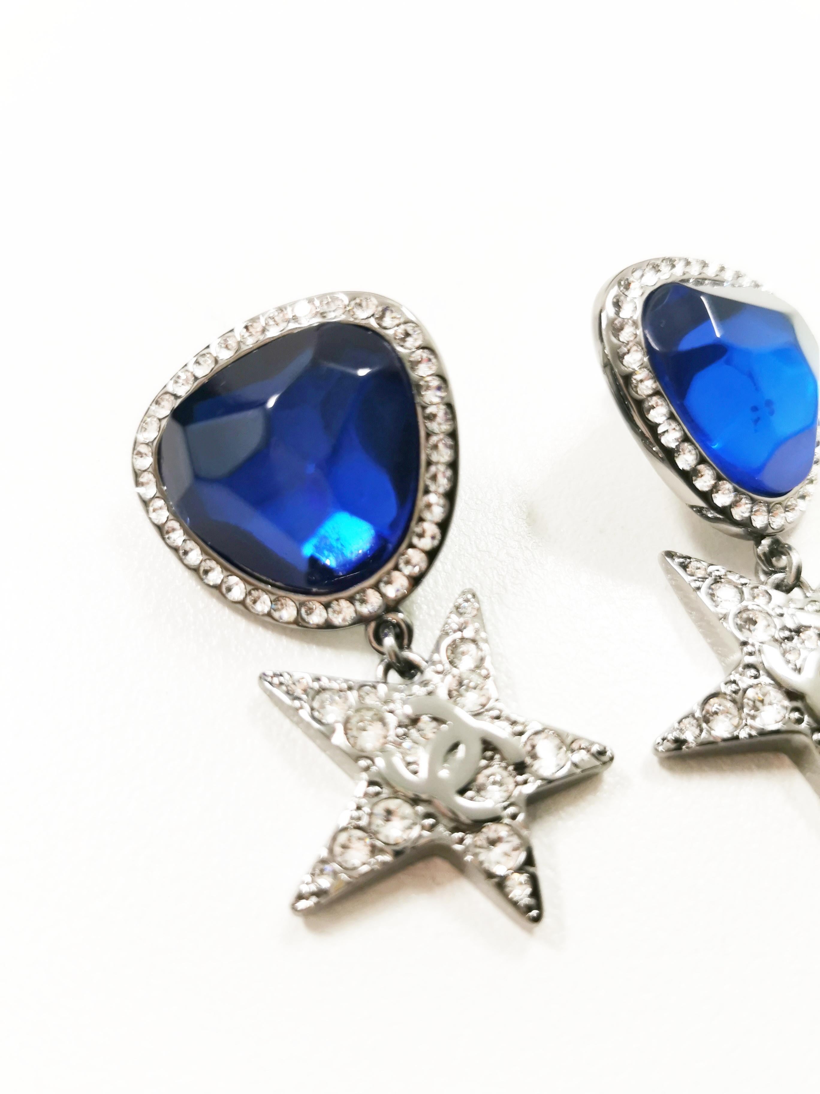 Elevate your style with the enchanting Chanel 21 Runway Blue Crystal with Rhinestones Drop Star Earrings in Gunmetal Silver – a celestial masterpiece that embodies the perfect blend of elegance and modernity. These exquisite earrings are a testament