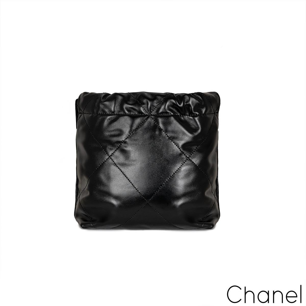 A lovely Chanel 22 Mini Bag. The exterior is crafted in quilted black shiny calfskin leather with gold-tone hardware. It features a gold tone logo in the front, a dangling CC logo medallion and comes with a versatile interwoven chain and leather