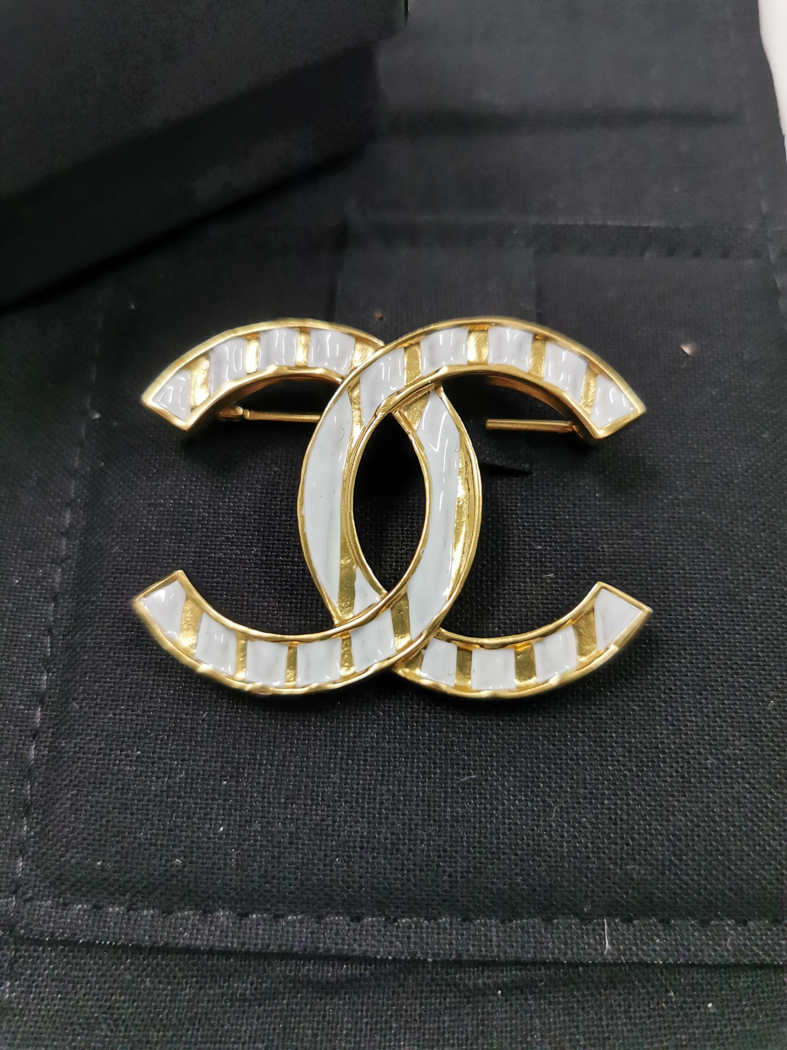Introducing the Chanel 23 Gold Black Resin with Gold Foil CC Large Brooch, a stunning accessory that captures the essence of Chanel's timeless elegance and impeccable craftsmanship. This brooch is a true statement piece that exudes sophistication