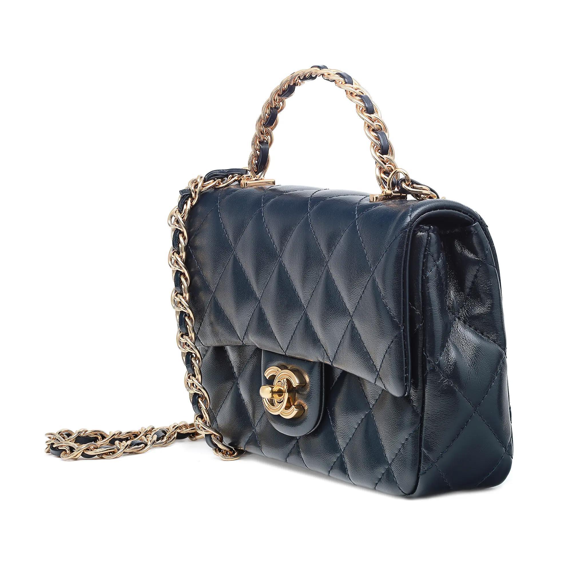 Display model. Chanel 23a Rectangular Top Handle Flap Crossbody bag featuring quilted lambskin leather with front flap. Color: Marine Blue. Metal logo turn lock buckle closure. Comes with a chain link and leather shoulder strap and a top handle.