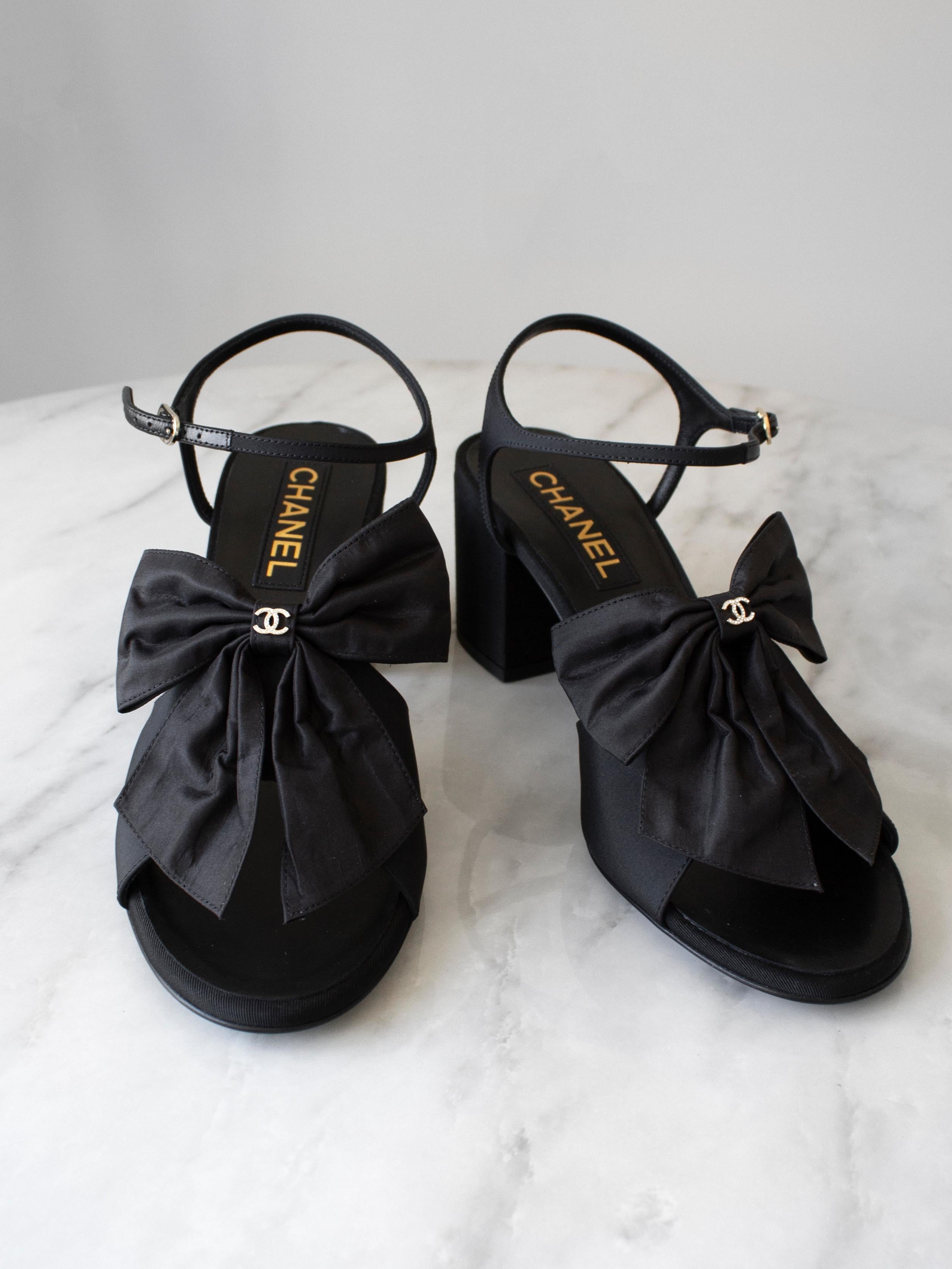 The most wanted black sandals from Chanel 24A collection. These cute sandals feature large silk bows embellished with CC logo, ankle straps and comfortable block heel. Heel height 2,6