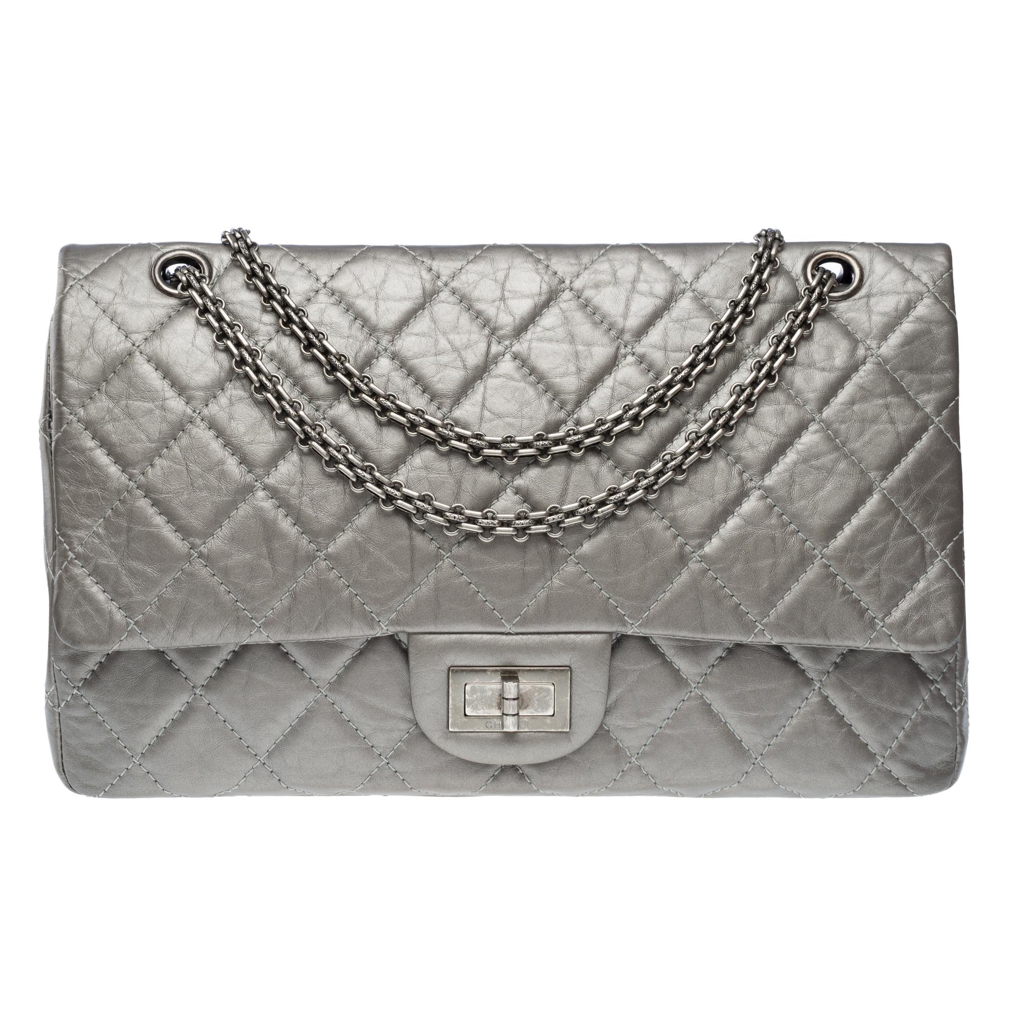 Sac à bandoulière à double rabat Chanel 2.55 en cuir matelassé argent métallique, garniture en métal argenté, anse en chaîne convertible en métal argenté pour un portage à la main, à l'épaule ou en bandoulière.

Fermeture MADEMOISELLE sur rabat en