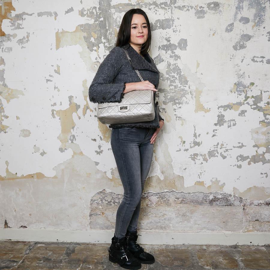 This beautiful 2.55 CHANEL double flap bag made of quilted silver crumpled leather. The hardware is in silver palladium metal. The interior is in silver leather with two flat patch pockets. 
It has a double flap with a snap. A flat pocket at the