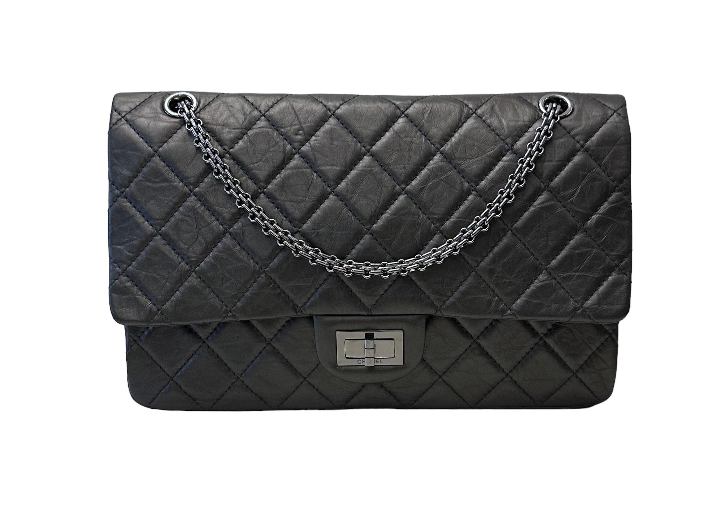 Ce magnifique sac d'occasion Chanel 2.55 Classic Doubleflap Maxi Bag - 5 pockets est le sac à main le plus emblématique du monde de la mode. Il est réalisé dans un superbe cuir de veau matelassé gris foncé vieilli. 
Il est doté d'une fermeture