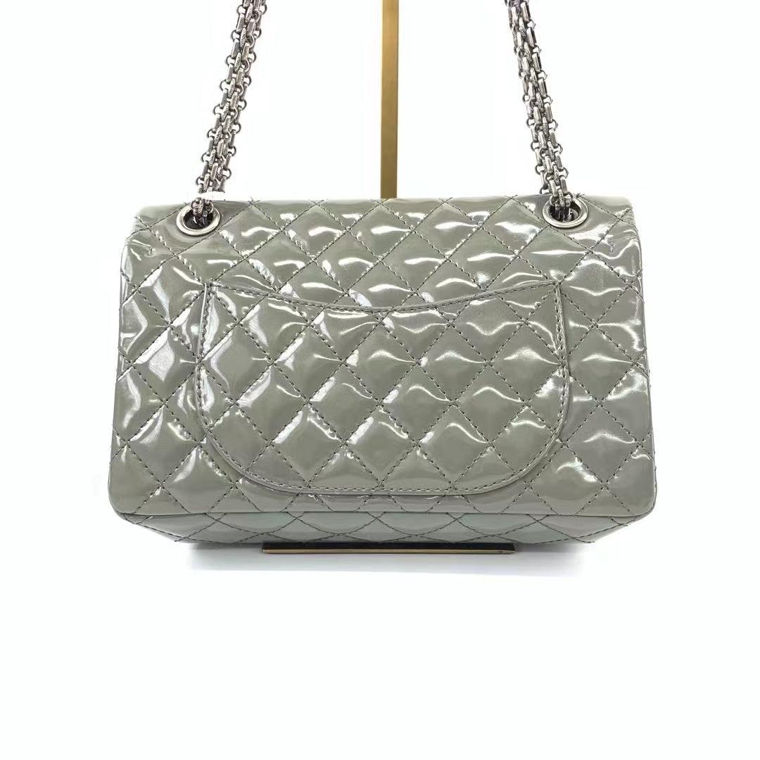 Chanel 2.55 Flap Bag Patent Leather Double Bottom Small Grey
These are professional photos of the actual bag.
  This particular Chanel 2.55 appears unremarkable from the front, but boasts twice the storage capacity of a standard 2.55.
  CONDITION: