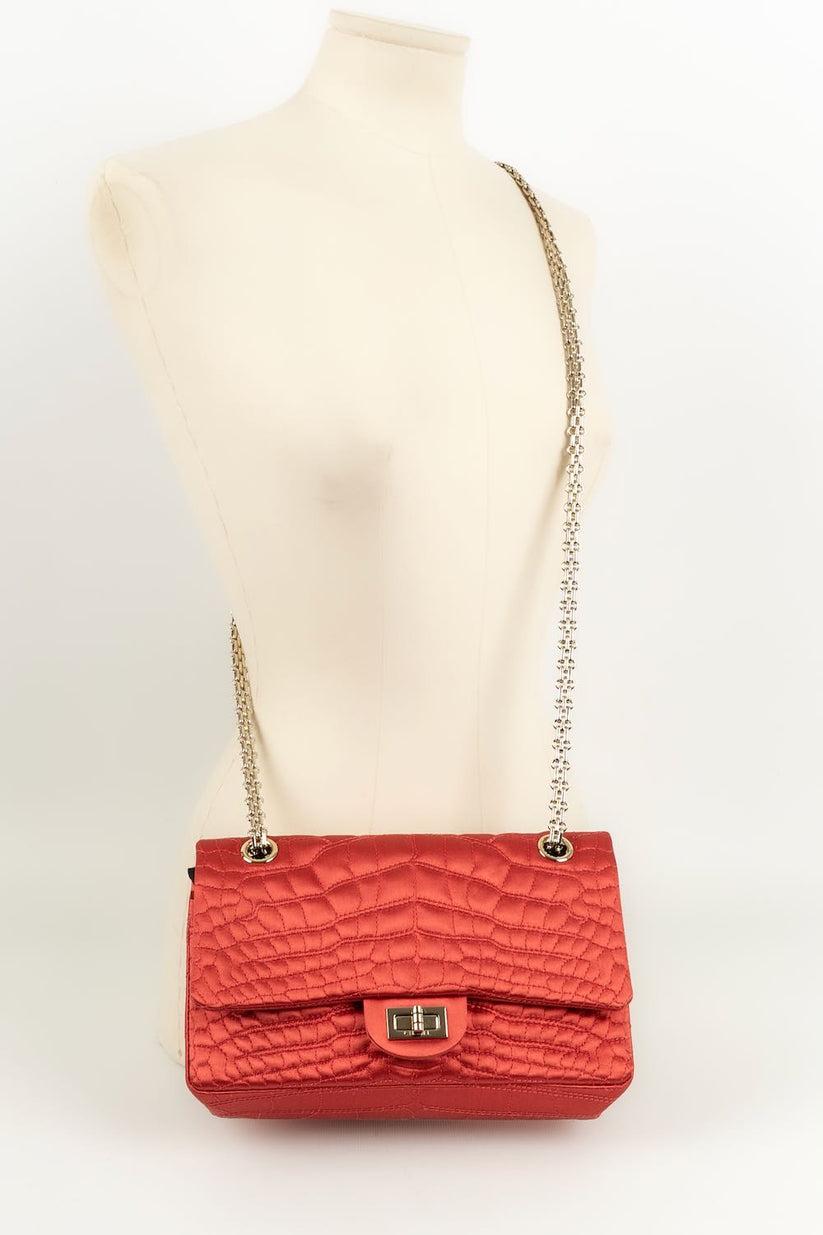 Chanel - (Made in France) Red silk bag with exotic leather effect. Attributes in gilded metal. 
Collection 2008/2009

Additional information: 

Dimensions: 
Length : 24 cm, Height : 14 cm, Depth : 7 cm, Handle : 95 cm 

Condition: 
Very good