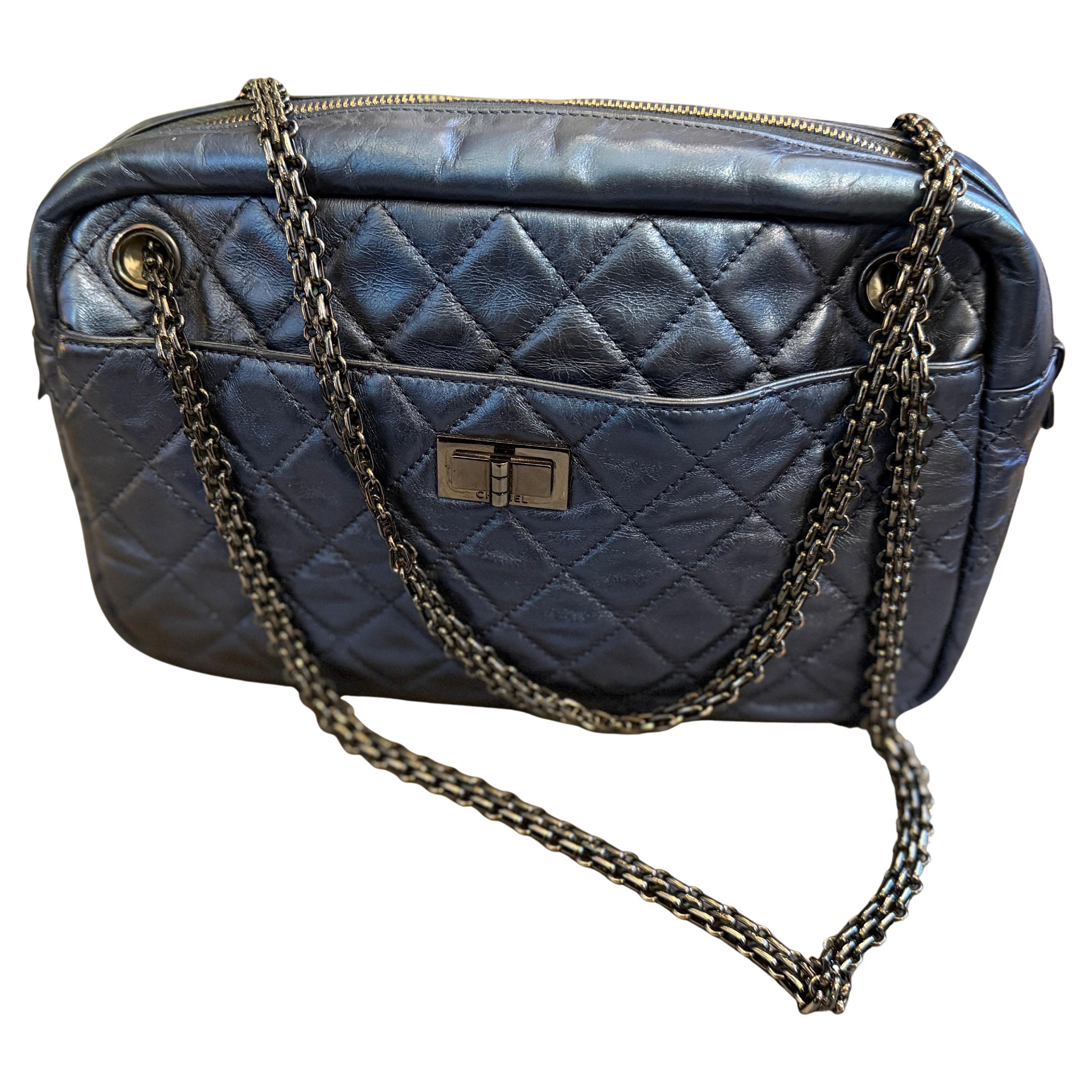 Si tratta di un'iconica borsa a tracolla Chanel in edizione limitata, caratterizzata da una splendida finitura in pelle trapuntata blu scuro metallizzata e da una tracolla a catena in rutenio nero/scuro. La borsa è presentata nella classica e