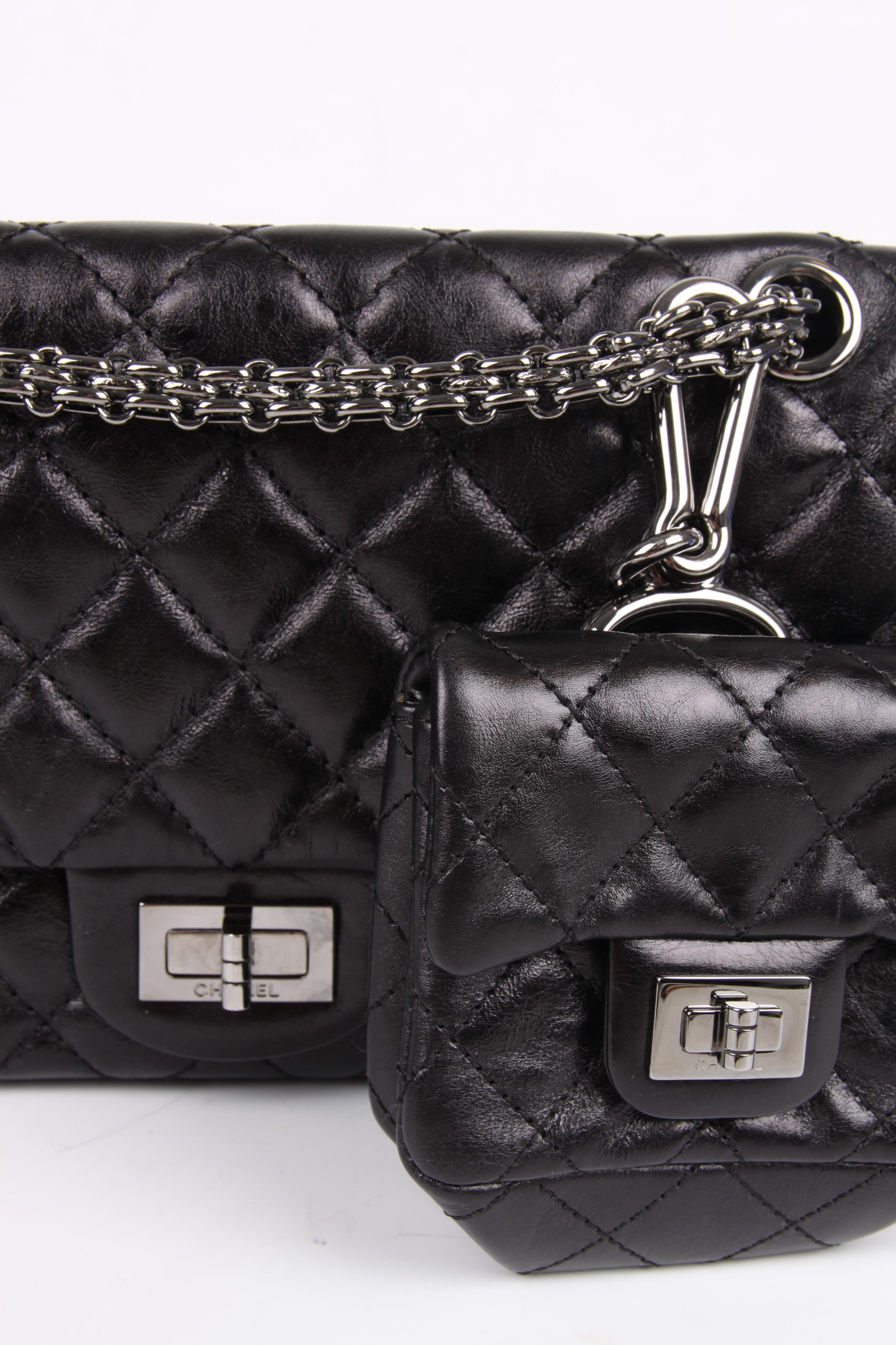 This is a limited edition from 2009, and it is soooo cool!

This black leather quilted Chanel Reissue Bag has a small mini-pochette hanging down from the silver-tone chain. Of course this small bag is detachable.

At the front a  silver-tone