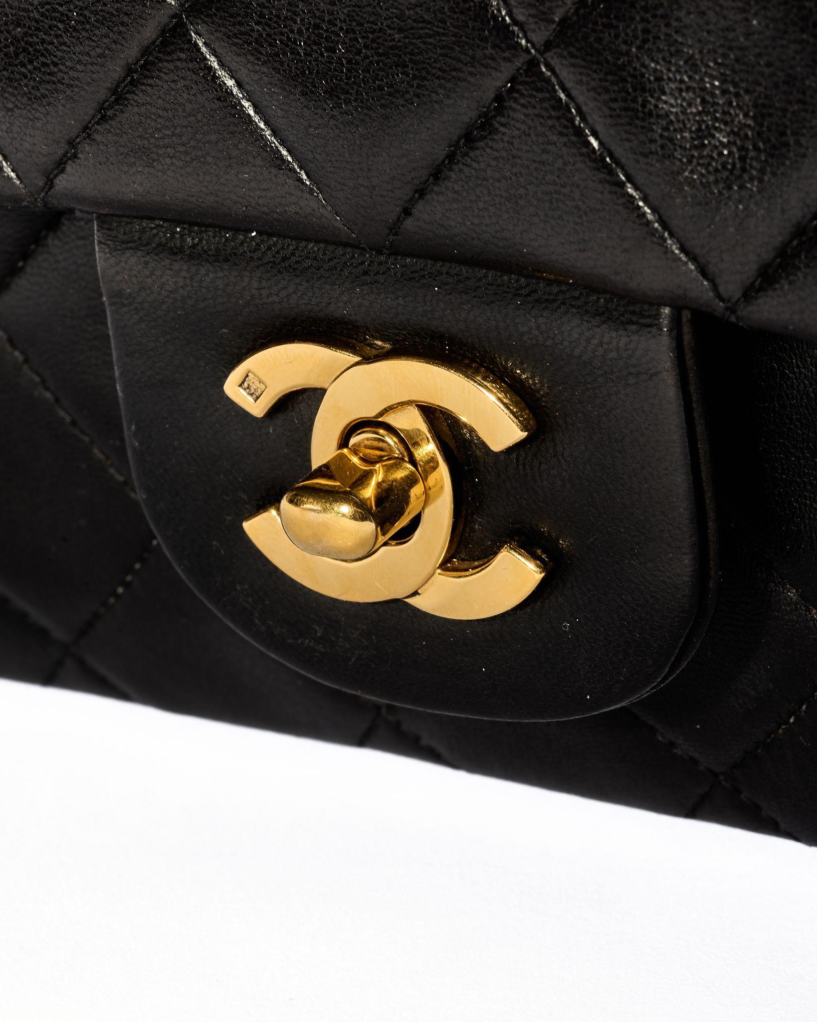 Chanel Designertasche, Linie Timeless, Modell 2.55, aus schwarzem Leder mit goldenen Beschlägen. Sie hat eine doppelte Klappe, eine innen mit einem Knopfverschluss und eine außen mit einem Drehverschluss mit dem klassischen 