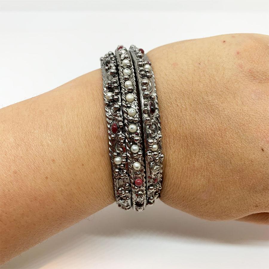 The bracelets come from Maison CHANEL. Each bracelet is made of silver metal, inlaid with small pearly and red pearls. Two bracelets are identical and the third thinner than the other two. They are symmetrical, the thinner in the middle of the two
