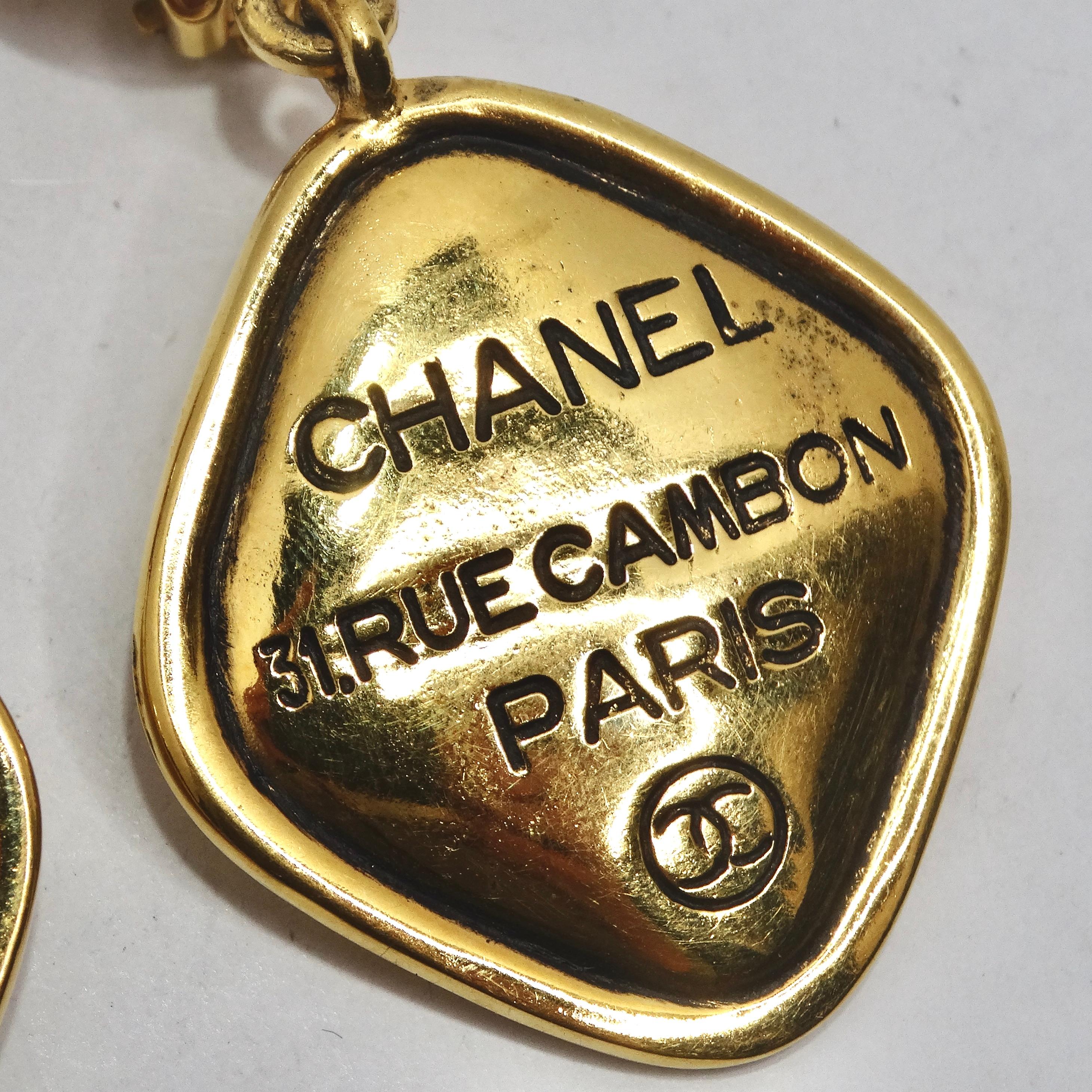 Introducing a stunning pair of classic Chanel earrings from the 1980s, the Chanel 31 Rue Cambon CC Gold Tone Clip On Drop Earrings. Engraved with 