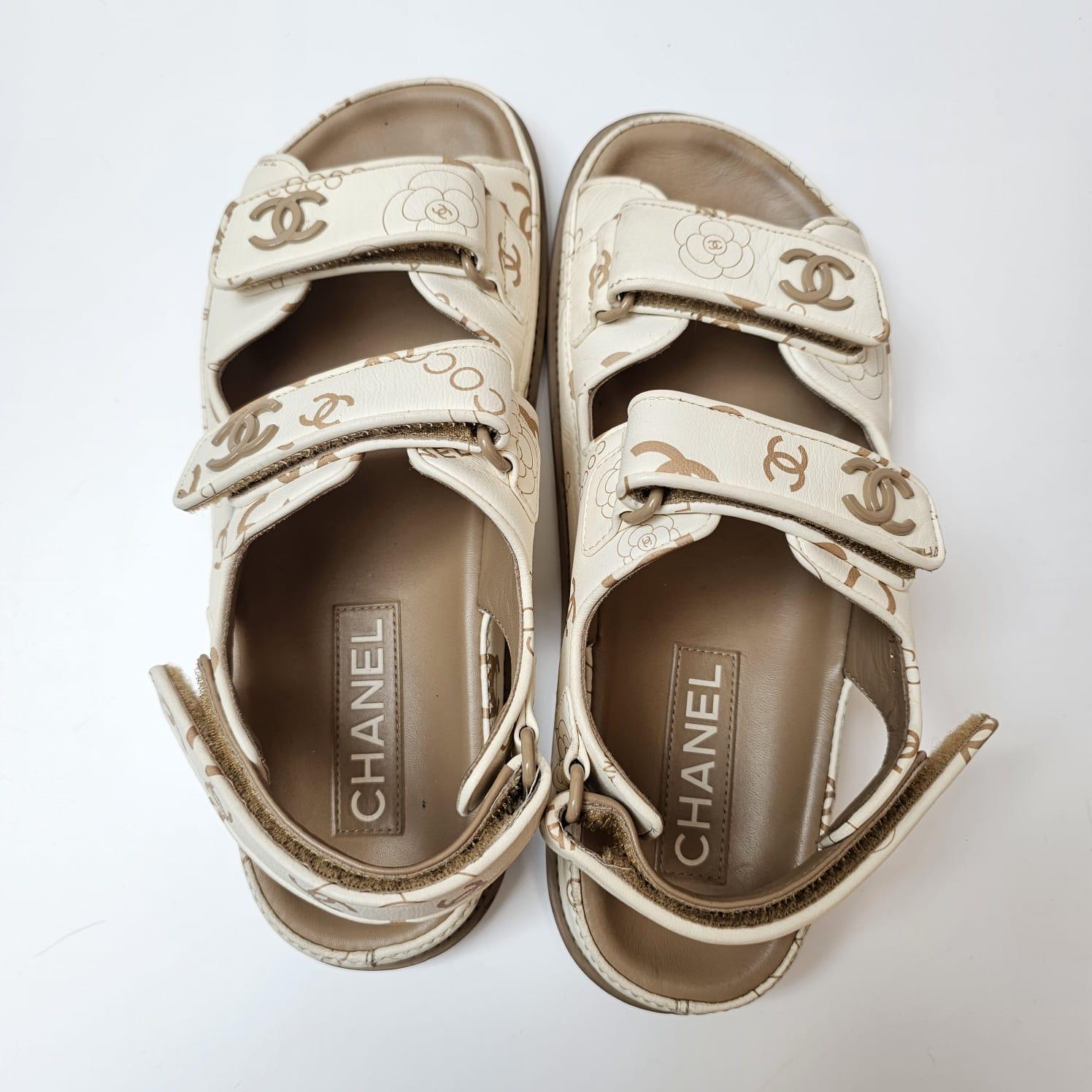Sandales Chanel en cuir blanc avec des imprimés de couleur crème. Style recherché. En état d'usure, avec de légers plis, des éraflures et des frottements sur l'ensemble. Signes d'utilisation visibles sur les semelles inférieures. La semelle