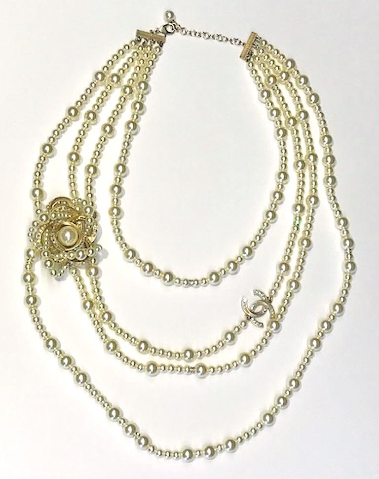 A magnificent Chanel four strand faux pearl bead necklace with large flower and Chanel interlocking CC logo from the Spring 2018 collation. The shortest top strand is 21 inches long and the longest bottom strand is 35 inches long. The four stands