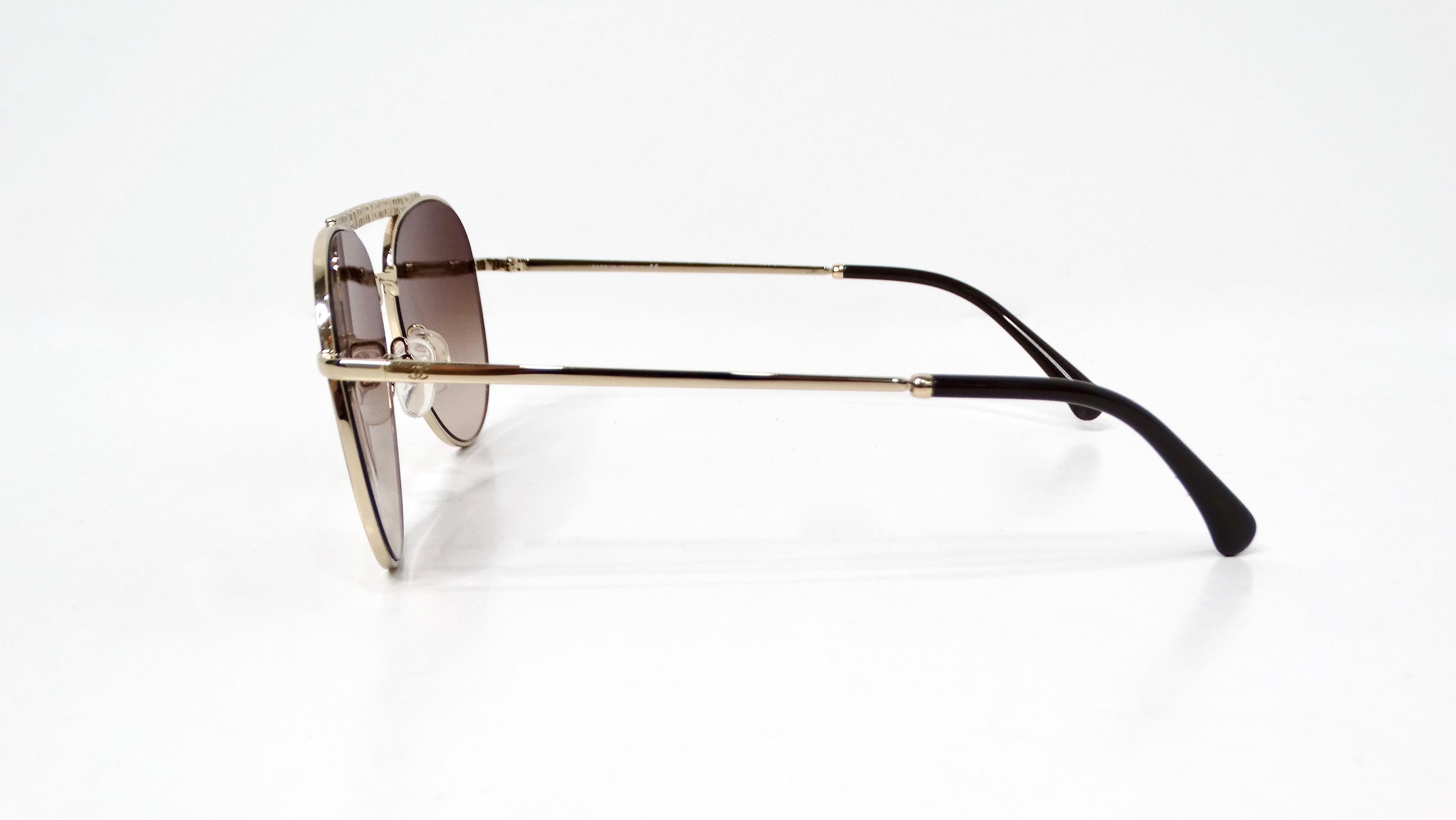 The Chanel 4231 Pilot Gold-Tone Metal Frame Aviator Sunglasses exude a perfect blend of luxury and contemporary design. Crafted with gold-tone metal frames, these sunglasses feature a refined elegance, accentuated by small interlocking CC engravings