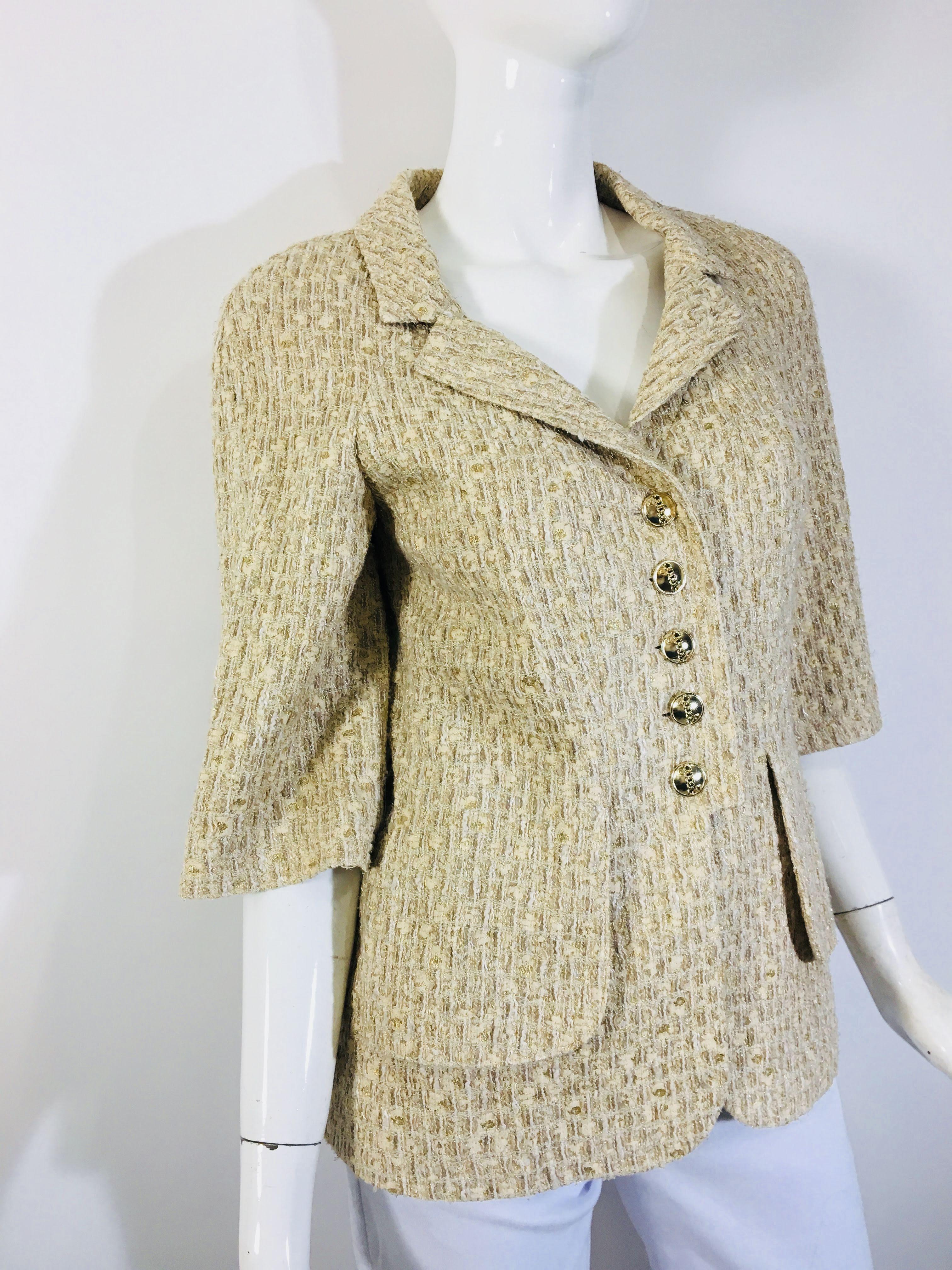 Chanel 5 Button Boucle Jacket in Cream Tweed
Gold Buttons with Chain Link Detail and Chanel Logo
3/4 Sleeve
Collar and Two Front Pockets
Made in France, 2007
Size 40