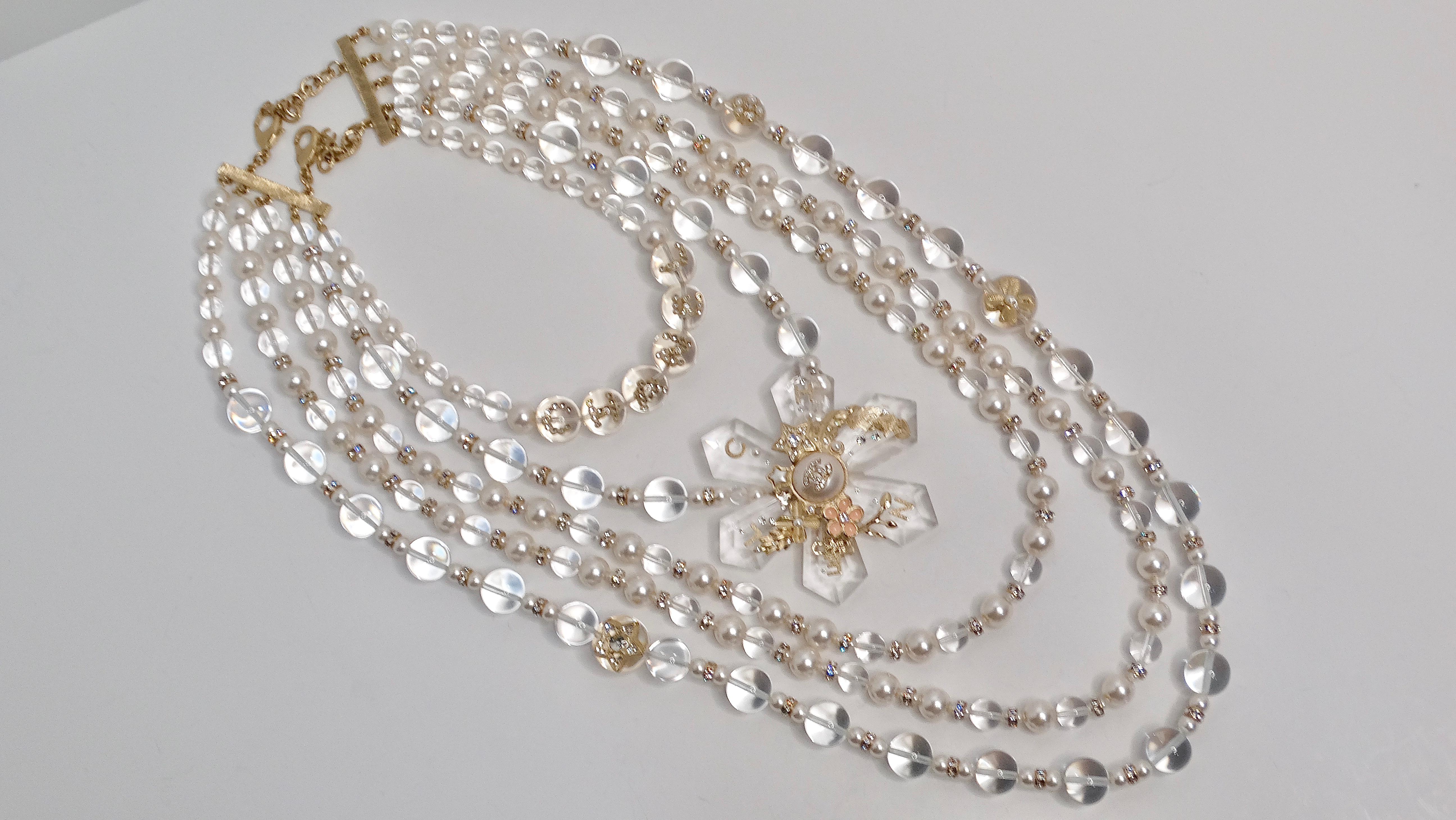 La collana Chanel 2019 con 5 strati di perle e motivi floreali è uno squisito pezzo forte che eleva senza sforzo qualsiasi look da sera. Realizzata con un occhio di riguardo per i dettagli, questa collana presenta uno splendido motivo floreale al