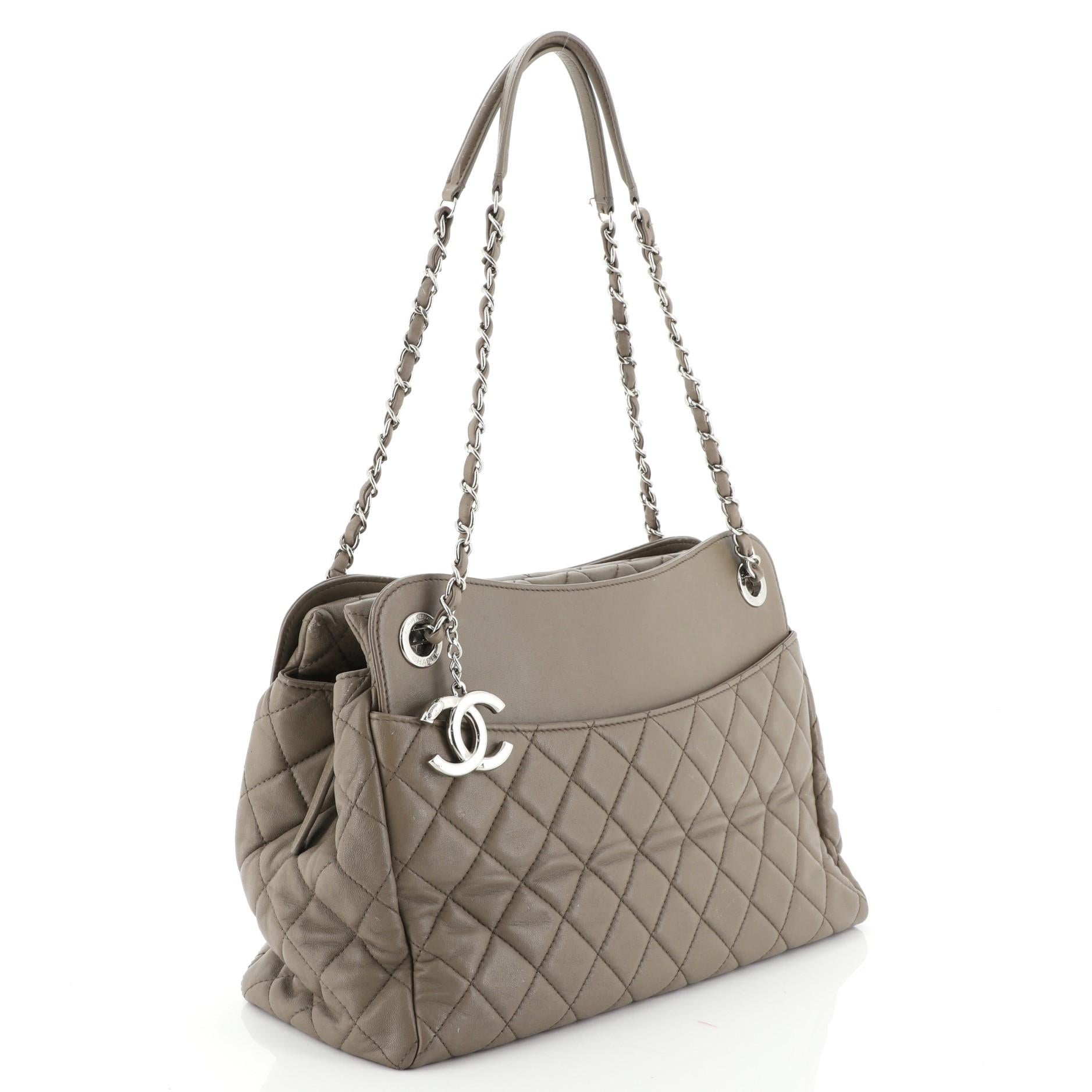 This Chanel 7 Tote Quilted Lambskin Large, crafted in neutral quilted lambskin leather, features woven in leather chain link straps with leather pads, exterior slip compartments and silver-tone hardware. Its magnetic snap closure opens to a green
