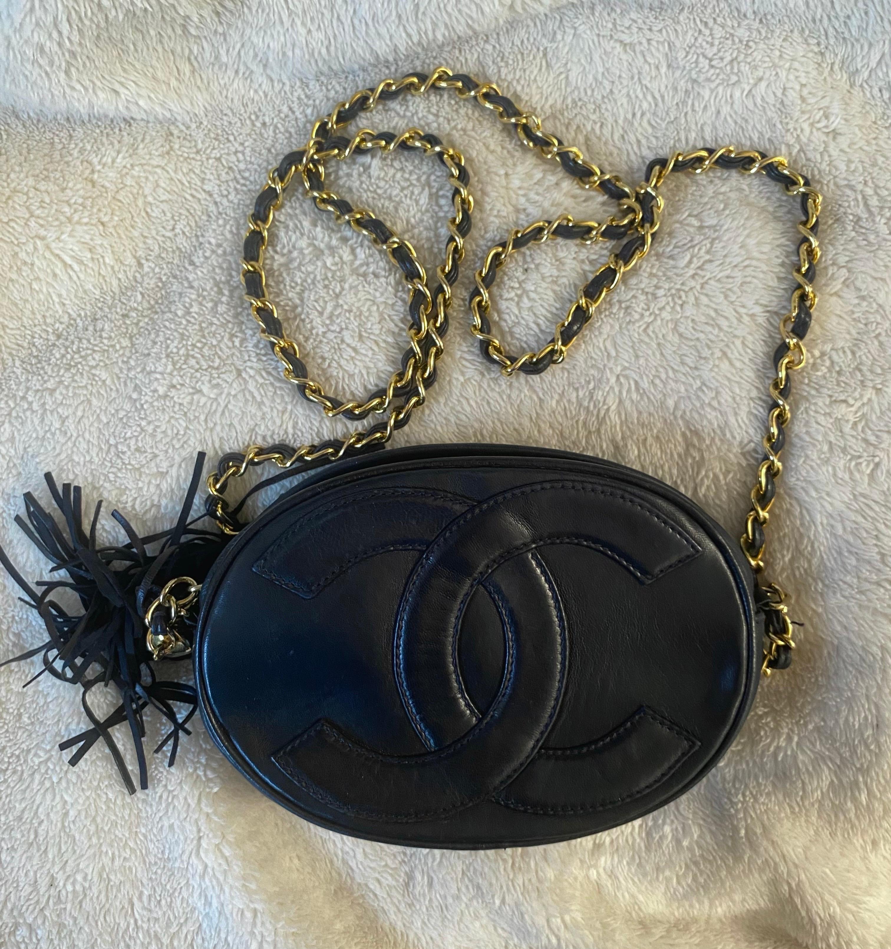 Mini borsa Chanel vintage anni '80 in pelle navy con logo centrale in rilievo e morbida nappa. Catena d'oro. Chiusura a zip. In ottime condizioni, ma presenta alcuni segni di invecchiamento in quanto vintage. Interni in pelle bordeaux; il codice non