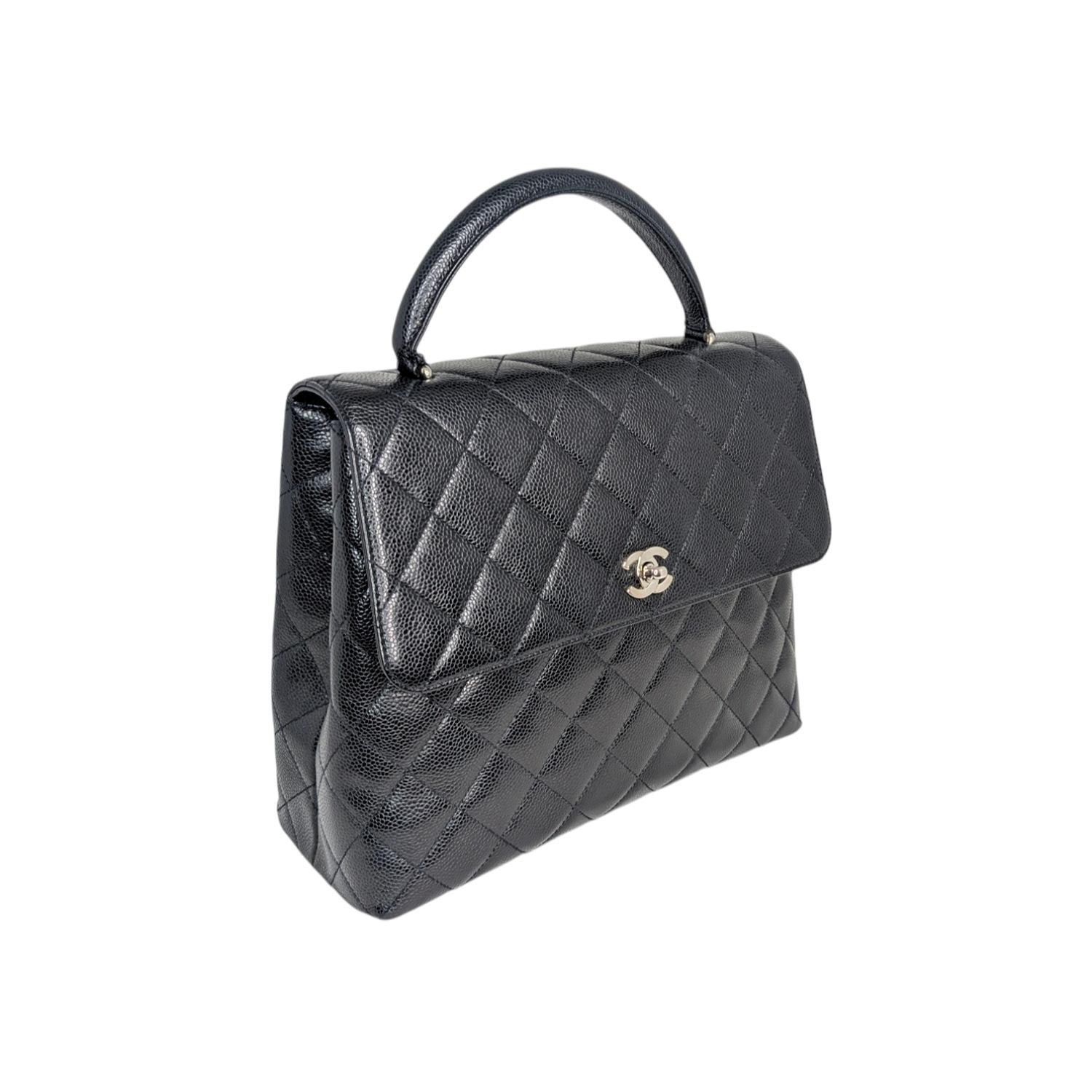 This timeless vintage bag is crafted from black caviar leather and features the iconic diamond quilting pattern. The bag has a single top handle, a rear patch pocket, and a ruthenium-tone CC turn-lock closure on the front flap. The interior is lined