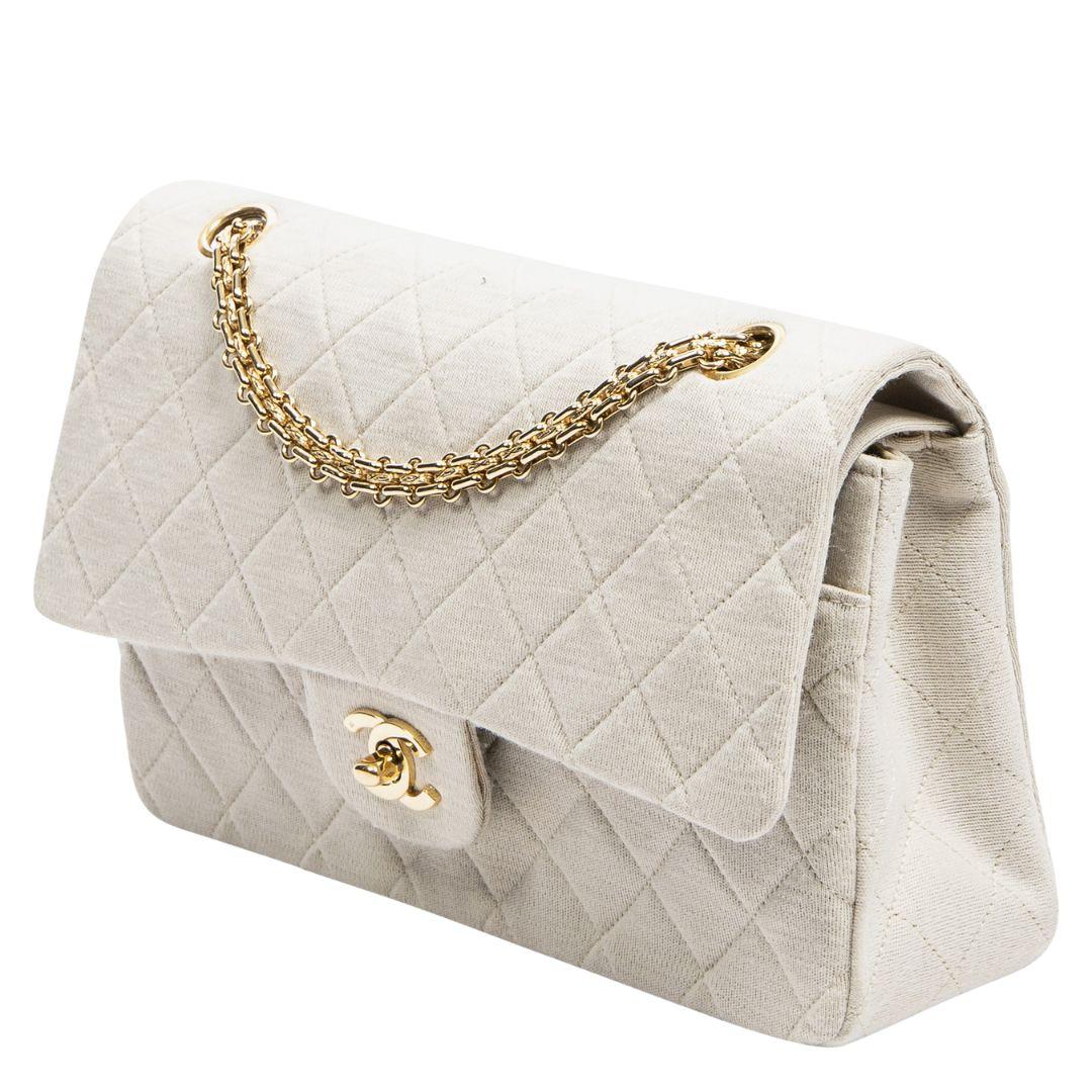 Beautiful summer piece! This classic 1989 vintage double flap is crafted in beautiful quilted jersey cotton with gold-tone hardware, vintage gold chain which can be doubled up or worn single. There is one exterior slip pocket. The CC turn-lock opens