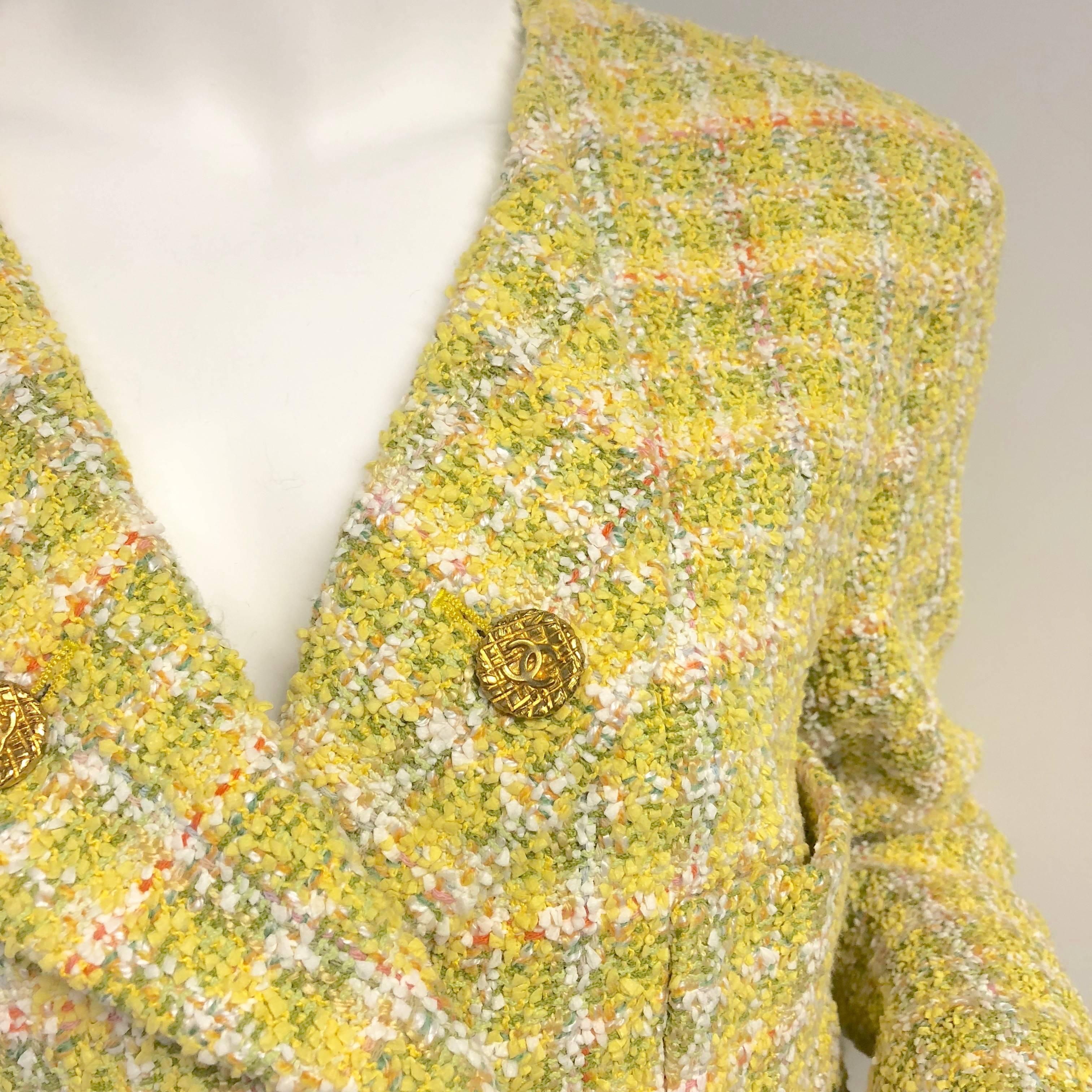 Vintage CHANEL yellow fantasy jacket with double breast and 5 gold quilted effect logo embossed buttons. Tweed has hints of mustard, chartreuse, pink and orange. 4 patch pockets in front. Each cuff has 3 working buttons. Signature CC embossed lining