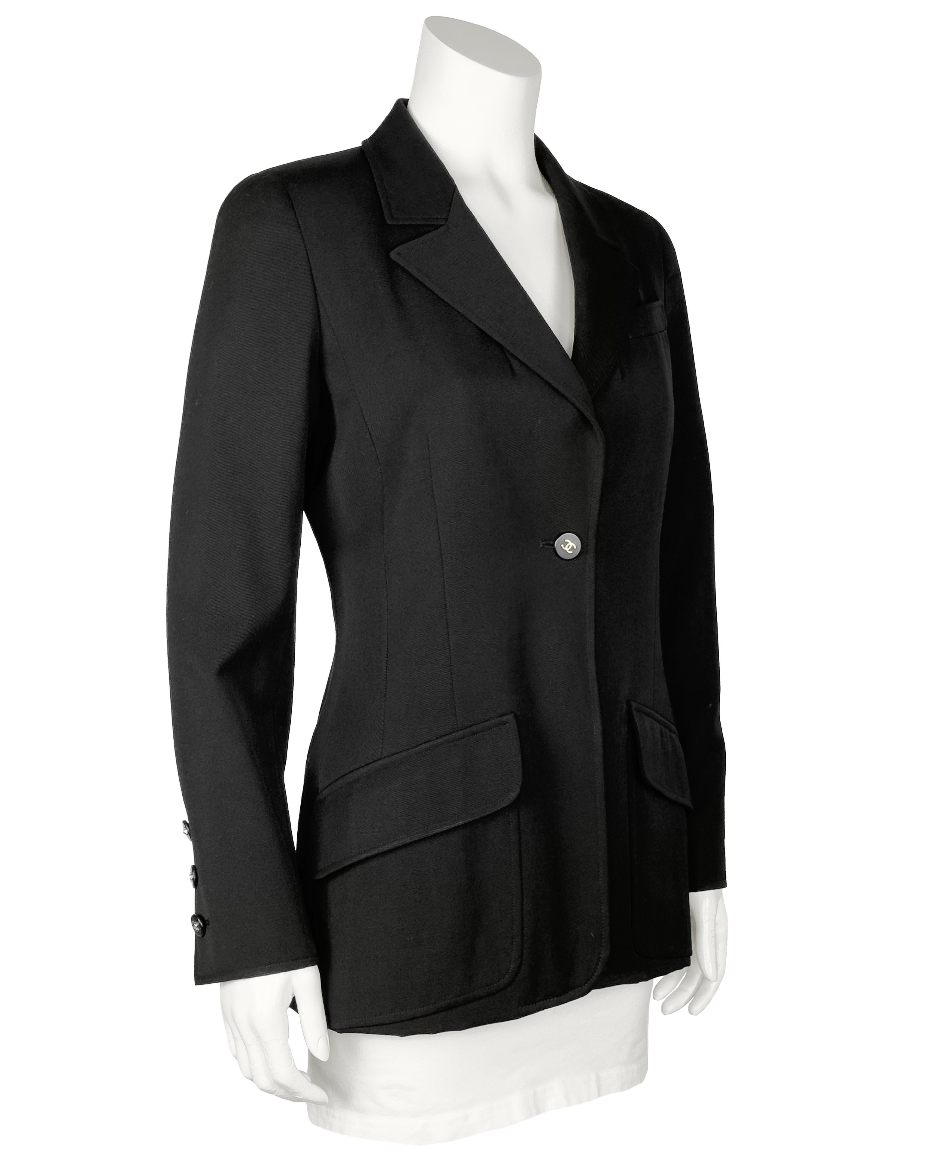 Blazer negro de lana de peso medio Chanel 97P de estilo largo con un solo pecho y botón con logotipo. Elegante estilo ecuestre entallado por la cintura, blazer largo forrado de seda. Cuello plano con muescas, un solo botón de resina negra con el