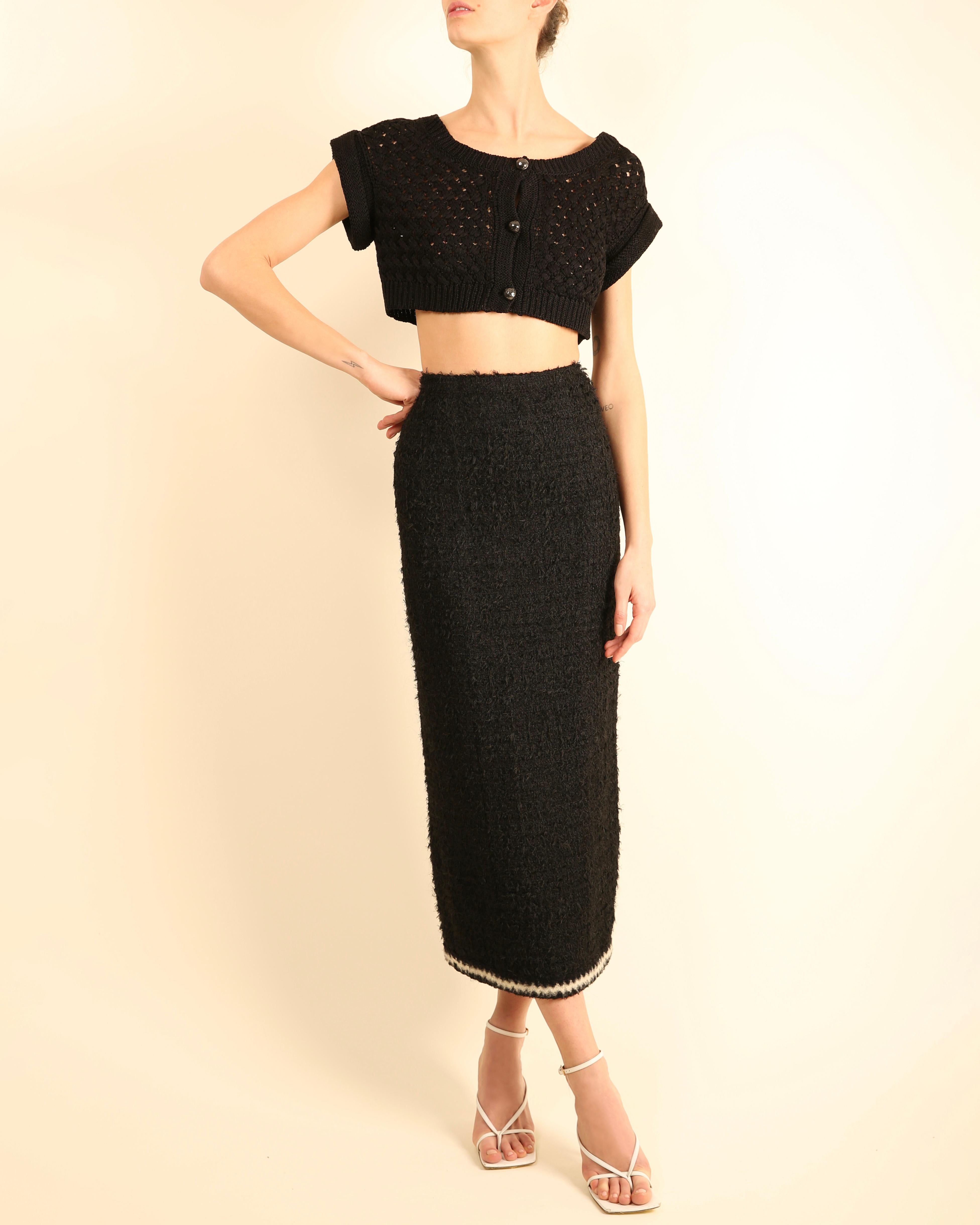 LIEBE LAI VINTAGE

Chanel 1998 (98 A) schwarzer Bouclé-Rock
Hoch taillierte Passform
Gerader Schnitt
Maxi-Länge
Weißer und schwarzer Zickzack-Besatz aus kontrastierendem Stoff
Der Rock hat einen Schlitz auf der Rückseite, die über 4 Knöpfe alle mit