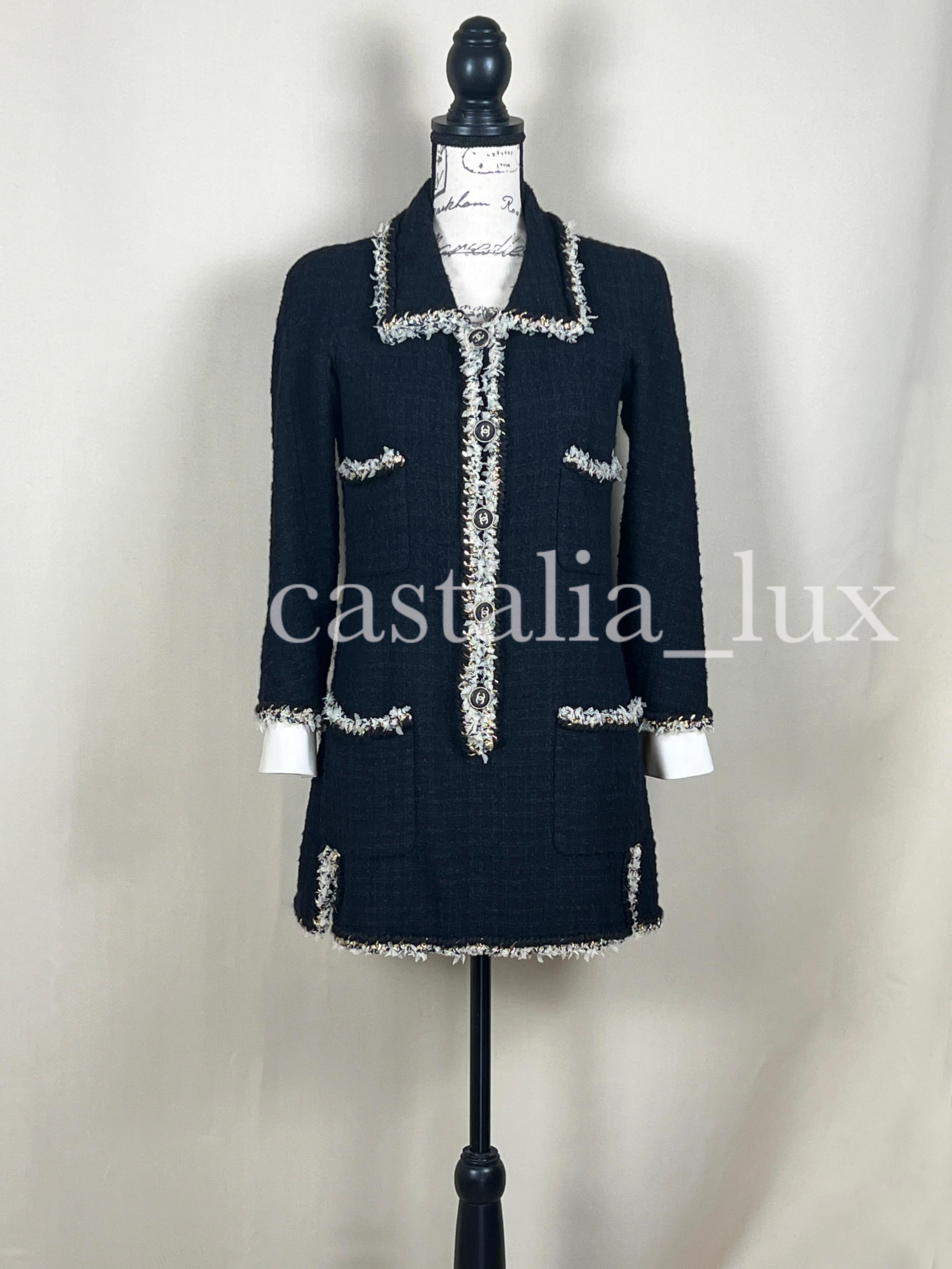 Une trouvaille rare !
Nouvelle robe en tweed noir rare de Chanel, ornée de la chaîne métallique emblématique de la marque.
- Prix boutique supérieur à 9 200
- Boutons massifs du logo CC
- manchettes en soie détachables
- doublure en soie ton sur