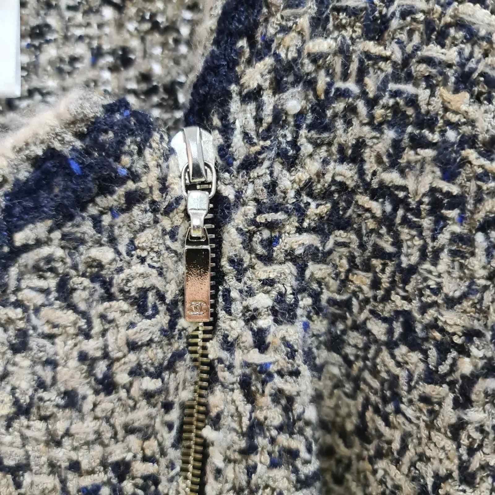 CHANEL A/W 2011 silk cashmere boucle side zipper jacket.
Hues of gray, blue, beige, and brown.
Long sleeves with single button closure at cuff.
Two way metal zipper closure traversing diagonally along front left side.
Two front patch pockets with