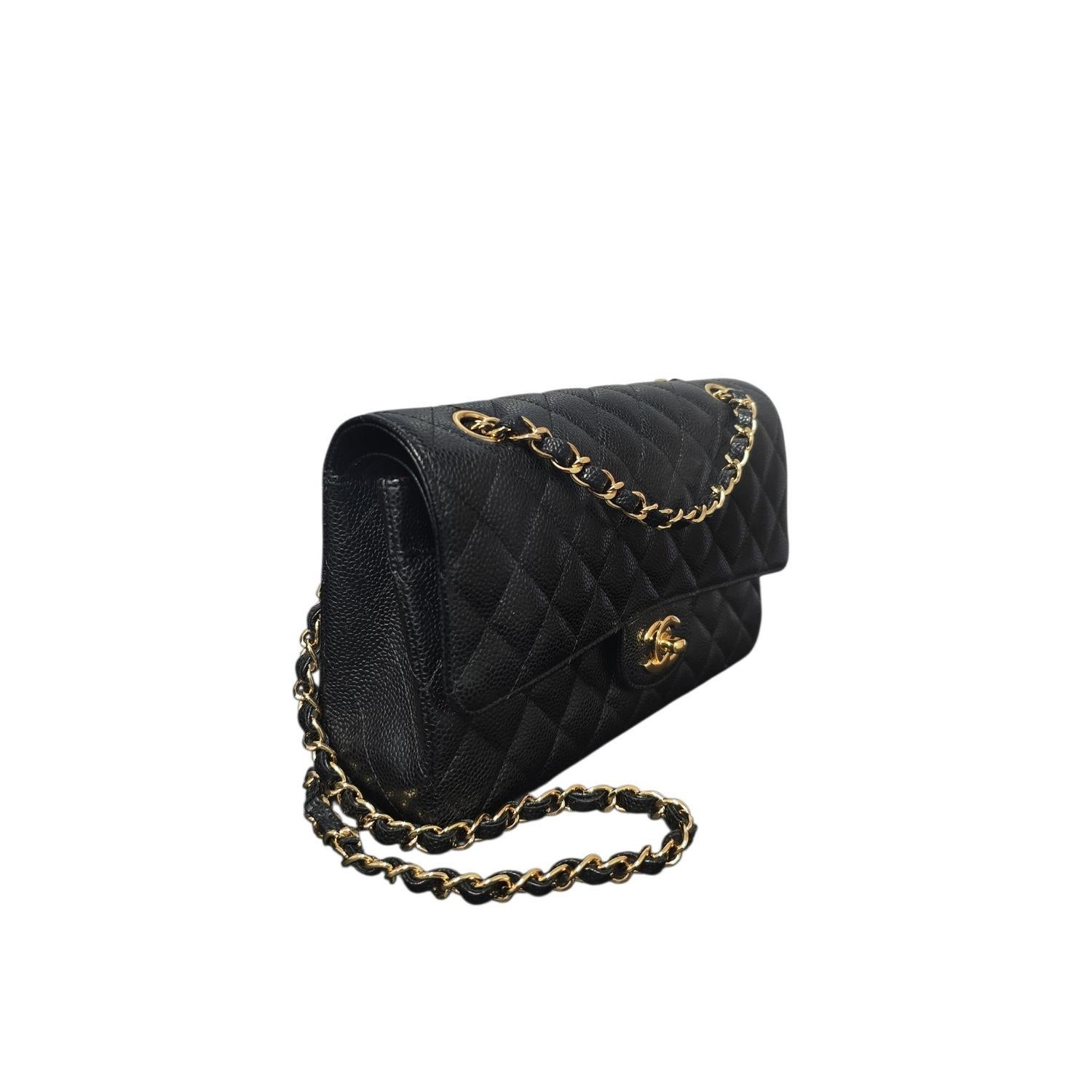The Chanel Classic Quilted Caviar Medium Double Flap Bag showcases timeless design and lasting quality. Crafted from black quilted caviar leather with gold-tone chain straps, it opens to a burgundy leather interior featuring multiple pockets for