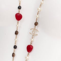 Collier sautoir Chanel A14C en résine rouge et noire, avec fausses perles et logo CC, muni d'une chaîne